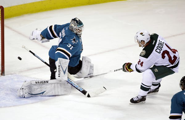 The Wild's Matt Cooke (24) scored past Sharks goalie Antti Niemi during the first period Saturday.