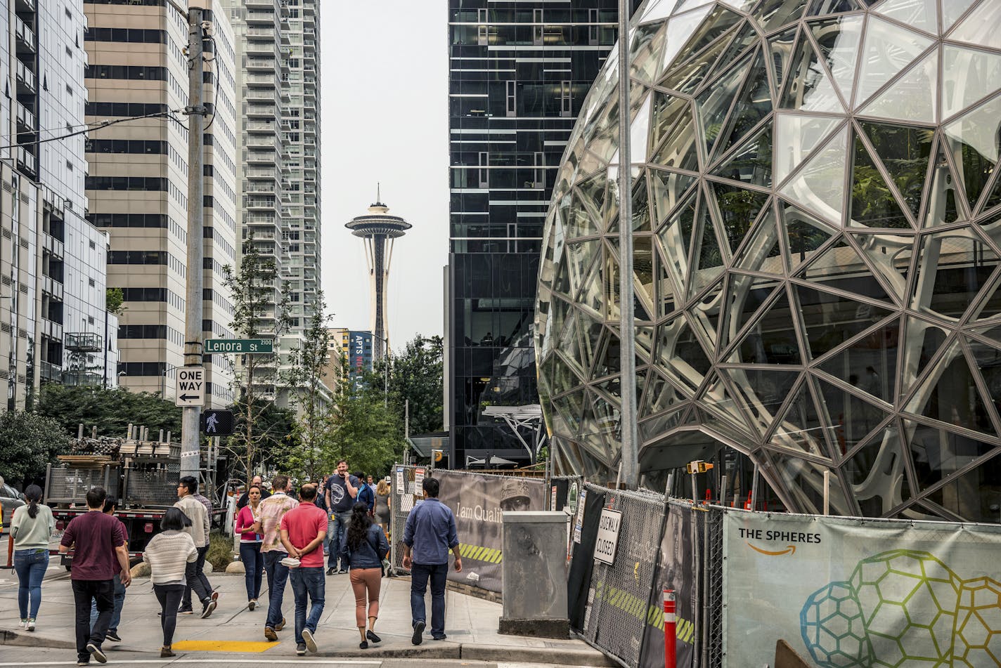 With the Space Needle observation tower visible in the distance, pedestrians walk past a recently built trio of geodesic domes that are part of the Seattle headquarters for Amazon, Sept. 7, 2017. The online retail giant said it was searching for a second headquarters in North America in 2017, a huge new development that would cost as much as $5 billion to build and run, and house as many as 50,000 employees. (Stuart Isett/The New York Times)