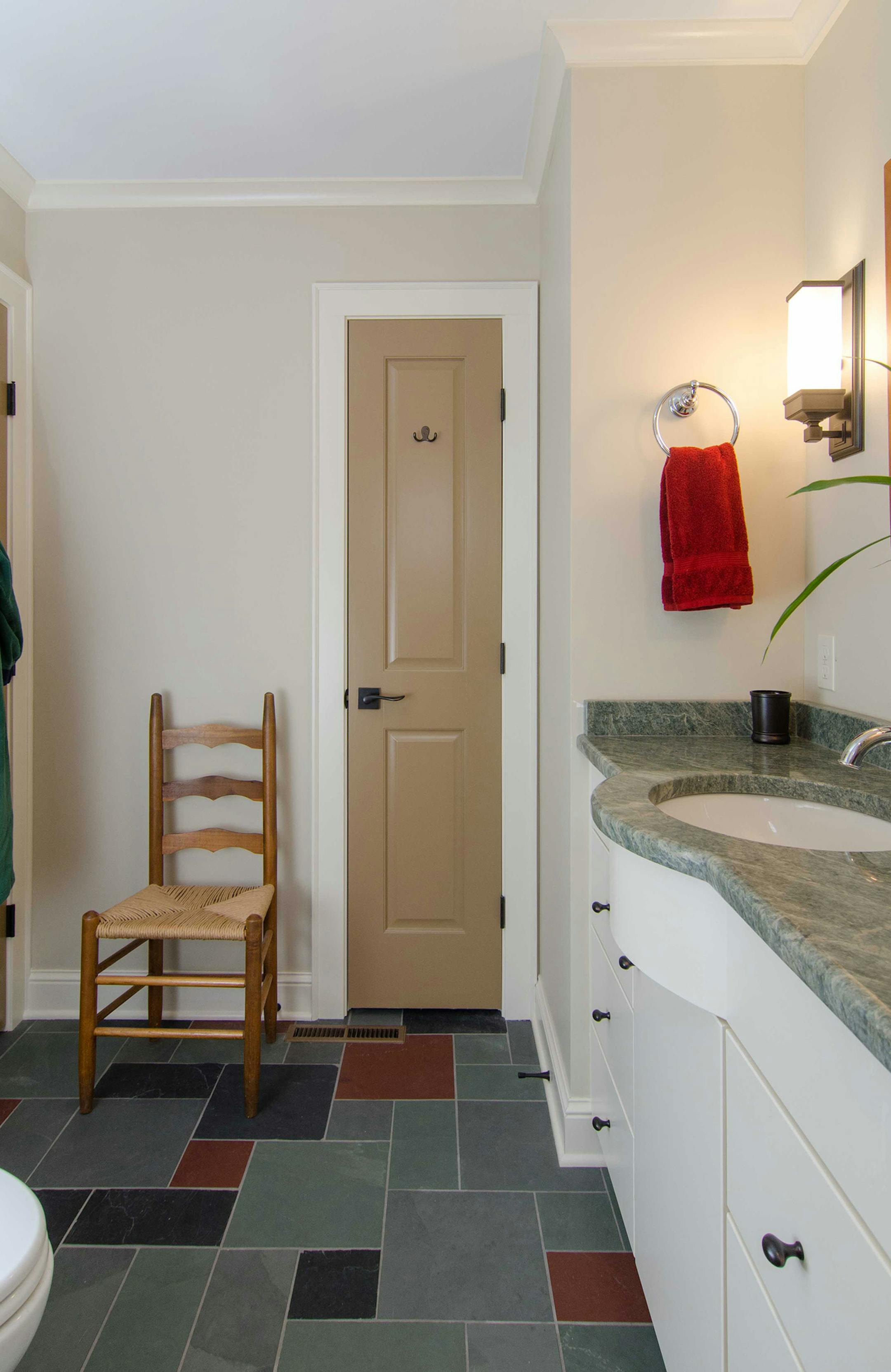 The expanded main floor bathroom features a subway-tiled walk-in shower with a window, granite-topped vanity, towel closet and several grab bars for support.