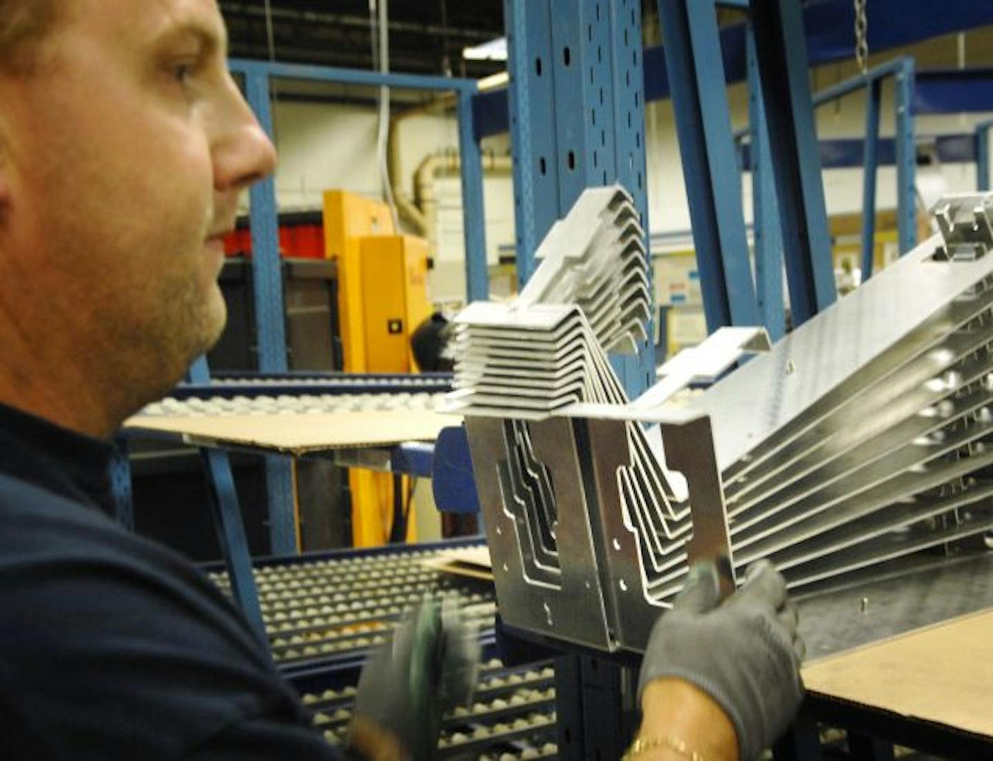 GLEN STUBBE � gstubbe@startribune.com Wednesday, May 23, 2007 -- Bloomington, Minn. -- Tim Causey shapes aluminum mounting brackets for solar collector panels at Dalsin Industries. manufacturing, minnesota, steel, jobs,