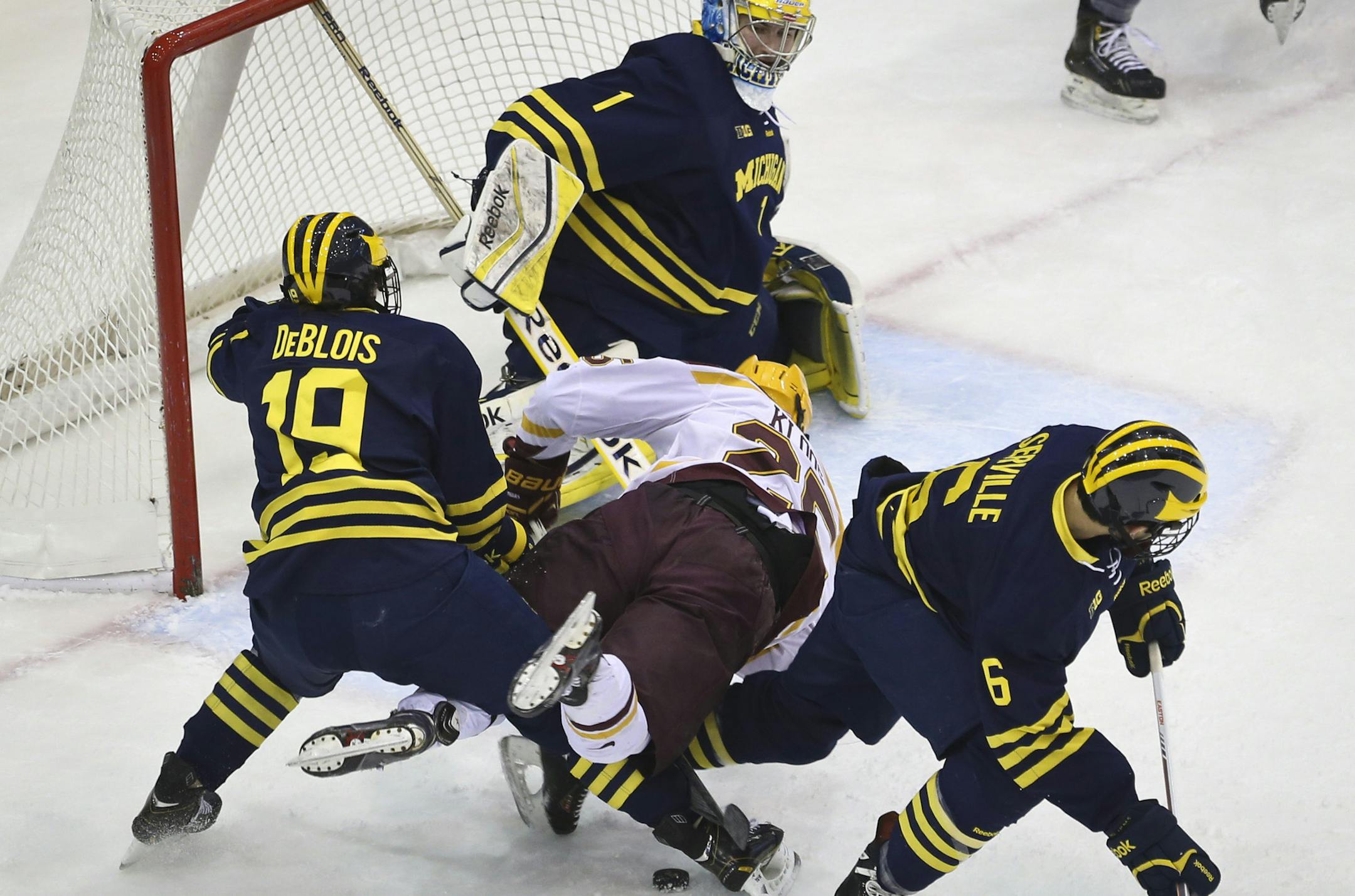 Minnesota's Justin Kloos lost the chance to score on Michigan goalie Steve Racine as he was squeezed by Michigan's Derek DeBlois (19) and Brennan Serville (6)during the first period of the MInnesota Gophers men's hockey vs. Michigan Wolverines on Friday, February 14, 2014 in Minneapolis, Minn. ] (RENEE JONES SCHNEIDER reneejones@startribune.com)