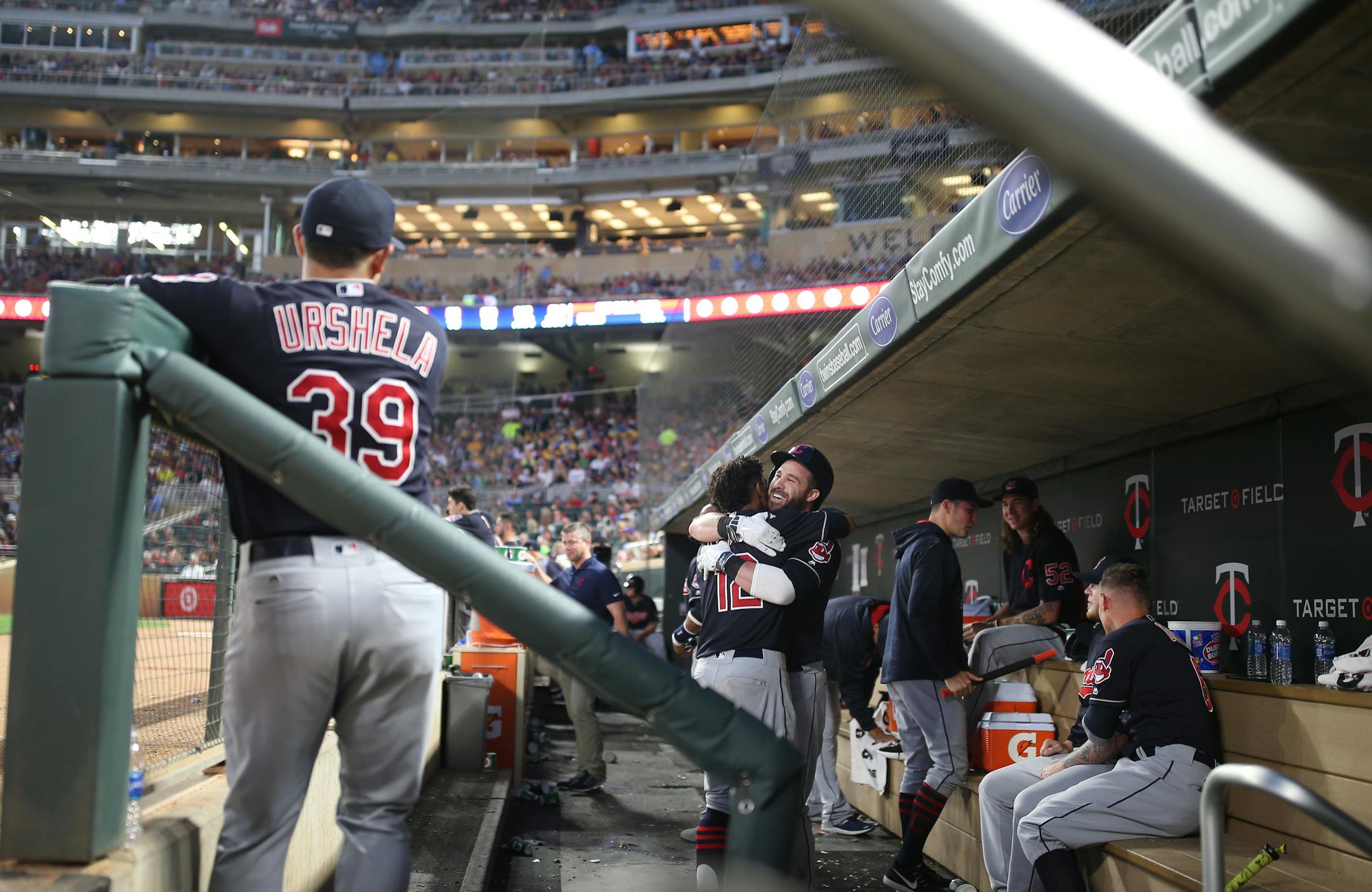 The Indians' Jason Kipnis got a hug in the dugout from Francisco Lindor (12) after his solo home run in the fifth inning against the Twins at Target Field on Tuesday. The Indians won 8-1.