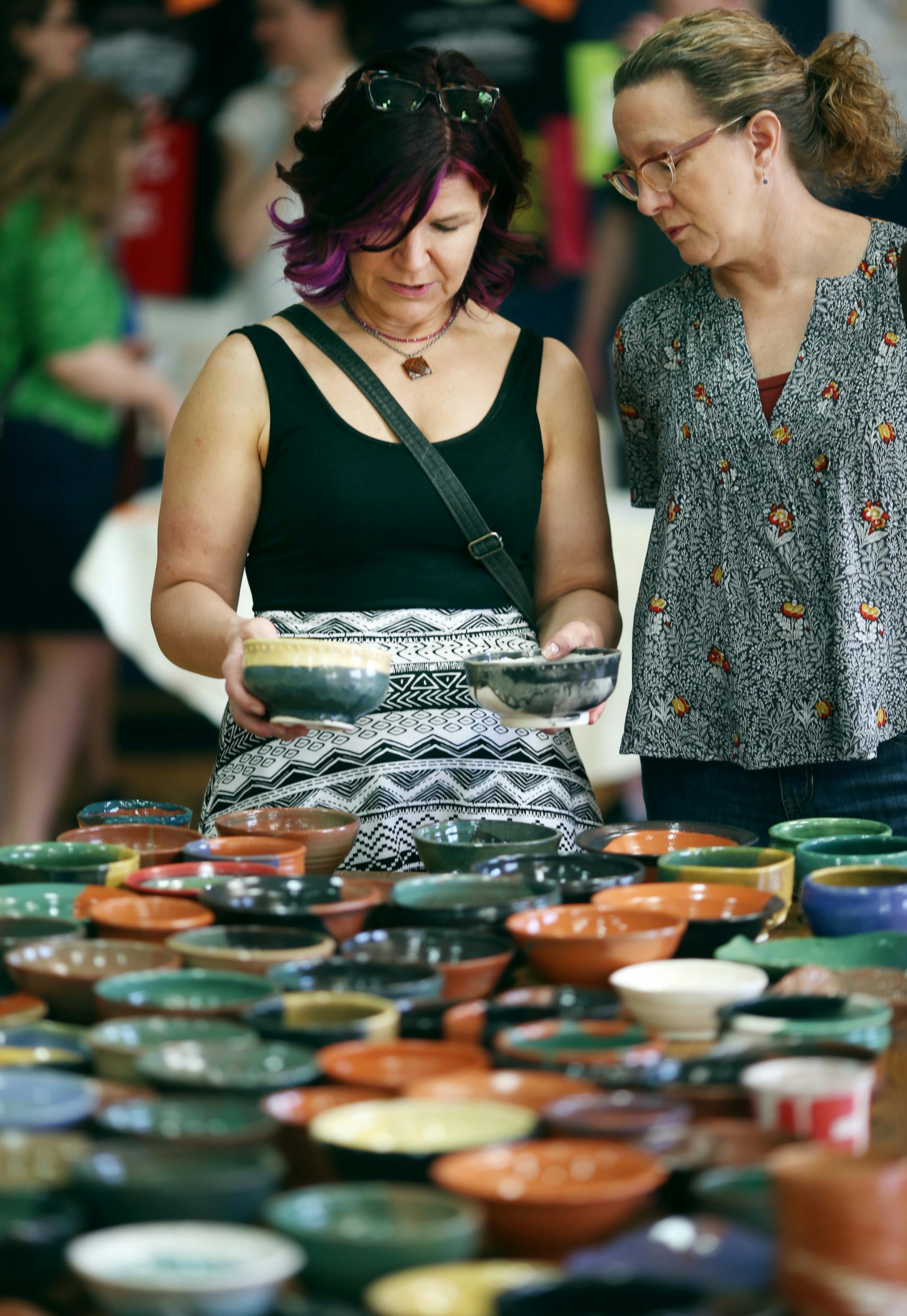 Katie DeBoer, left, and Kathy Jantzen closely scrutinized their choices to find the perfect ceramic bowl to buy and fill at the third annual Empty Bowls NE at the Eastside Neighborhood Services Center in Minneapolis.