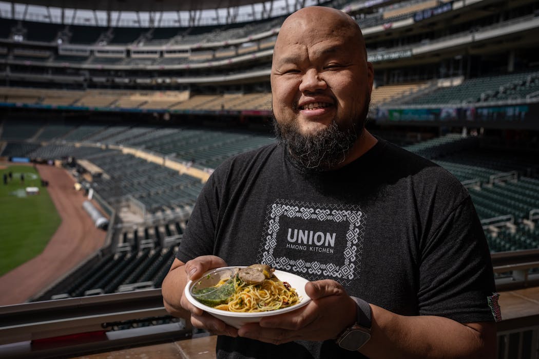 Yia Vang of Union Hmong Kitchen holds his Hmong sausage with Khao Sen rice noodle bowl.