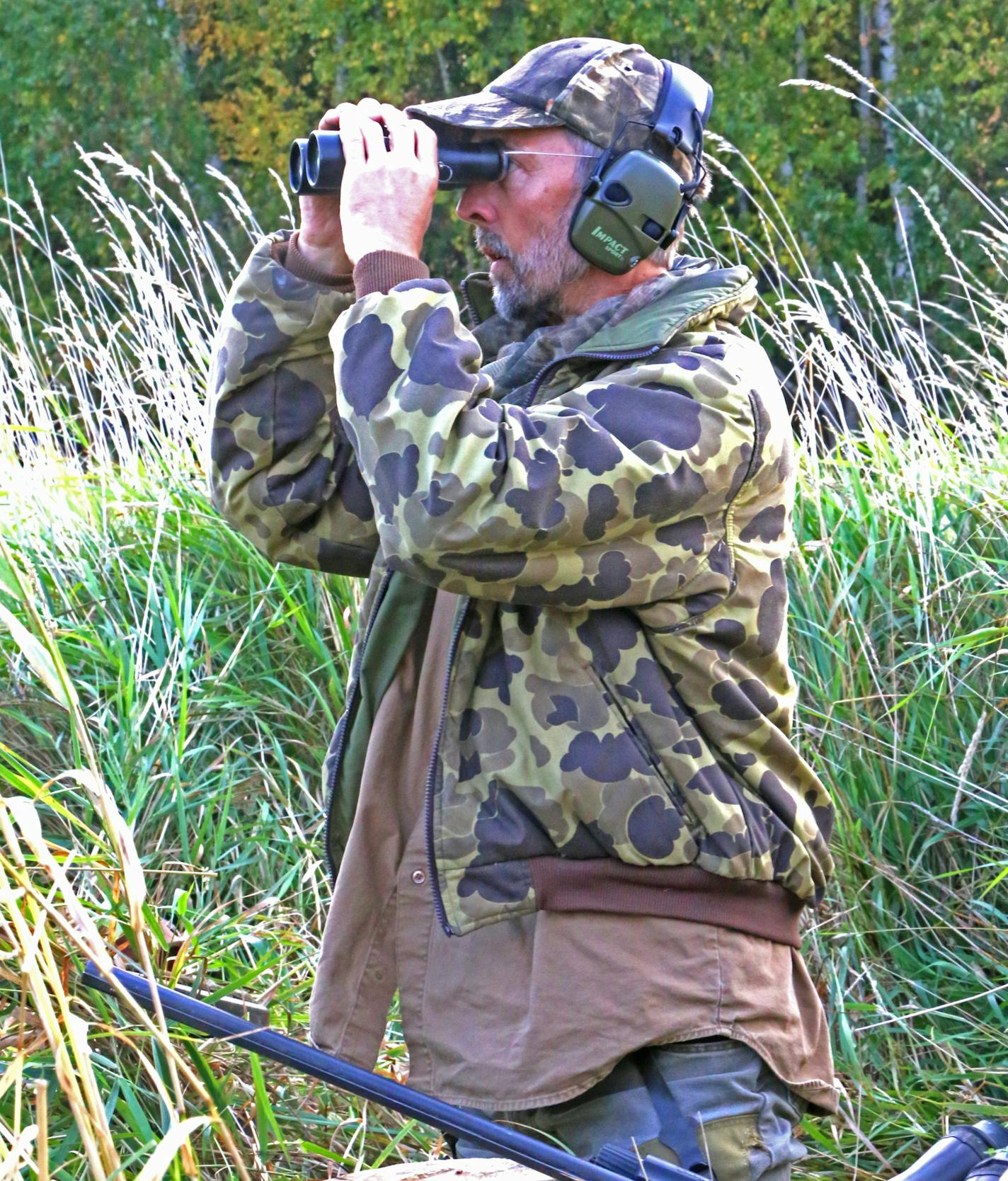 Wildlife artist Joe Hautman seeks a close-up of ducks trading in the distance on warm breezes Saturday morning. Joe, Jim and Bob Hautman have won the federal duck stamp contest a collective 10 times.