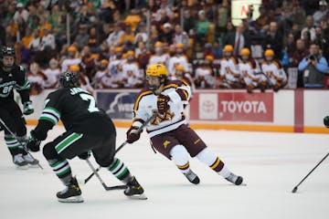 The Gophers’ Jimmy Snuggerud (81) tried to work around North Dakota’s Chris Jandric (7) on Saturday night at 3M Arena at Mariucci.