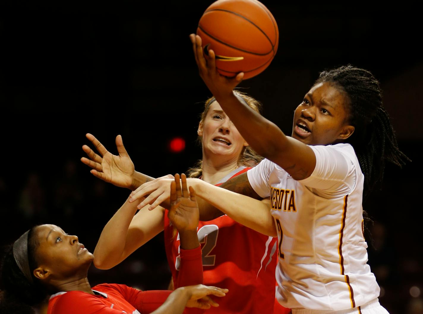 New Mexico's Bryce Owens (12) and Kianna Keller (32) got tangled up with the Gophers' Karley Barnes (32) looking to control the ball.