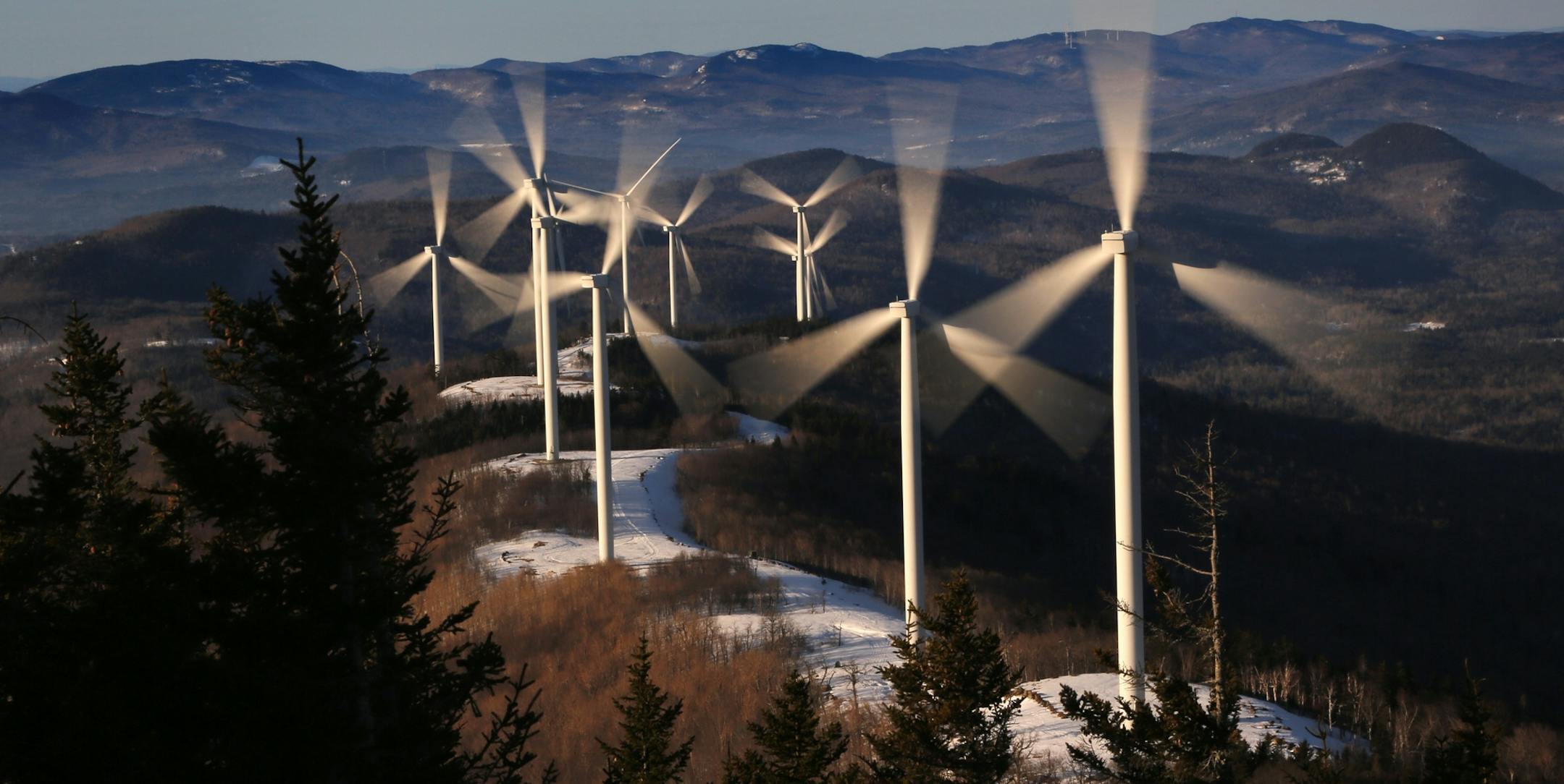 FILE - In this March 19, 2019 file photo, the blades of wind turbines catch the breeze at the Saddleback Ridge wind farm in Carthage, Maine. Scientists say emissions worldwide need to start falling sharply from next year if there is to be any hope of achieving the Paris climate accord’s goal of capping global warming at 1.5 degrees Celsius (2.7 Fahrenheit). (AP Photo/Robert F. Bukaty, File)