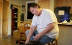 Brad Teslow, a former gym teacher,ties his shoes at his apartment before heading to work Wednesday, Feb. 27, 2016, in St. Paul, MN. ](DAVID JOLES/STAR