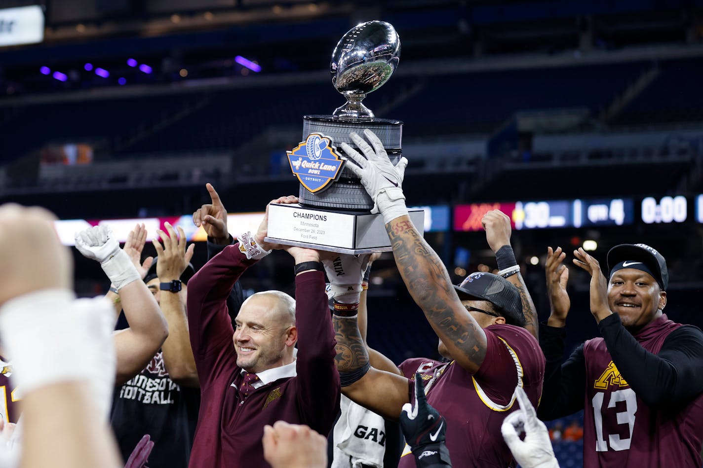 Minnesota coach P.J. Fleck, left, and running back Darius Taylor hold the trophy following the team's 30-24 win over Bowling Green in the Quick Lane Bowl NCAA college football game Tuesday, Dec. 26, 2023, in Detroit. (AP Photo/Al Goldis)