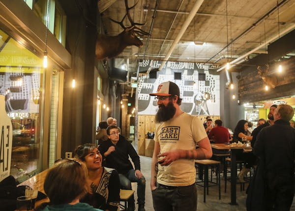 Eastlake Craft Brewery owner Ryan Pitman mingles with customers while enjoying a Nicollet Mauler (black IPA) in the Midtown Global Market Friday, Dec.