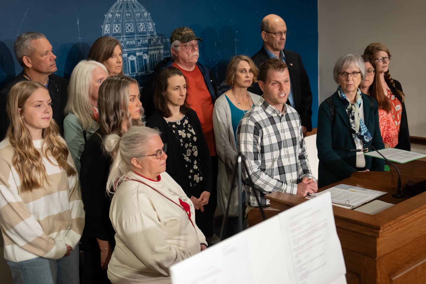 Mike Dicks, at the podium, and other Woodbury residents called on their senator, Nicole Mitchell, to resign after her felony charge for burglary.  