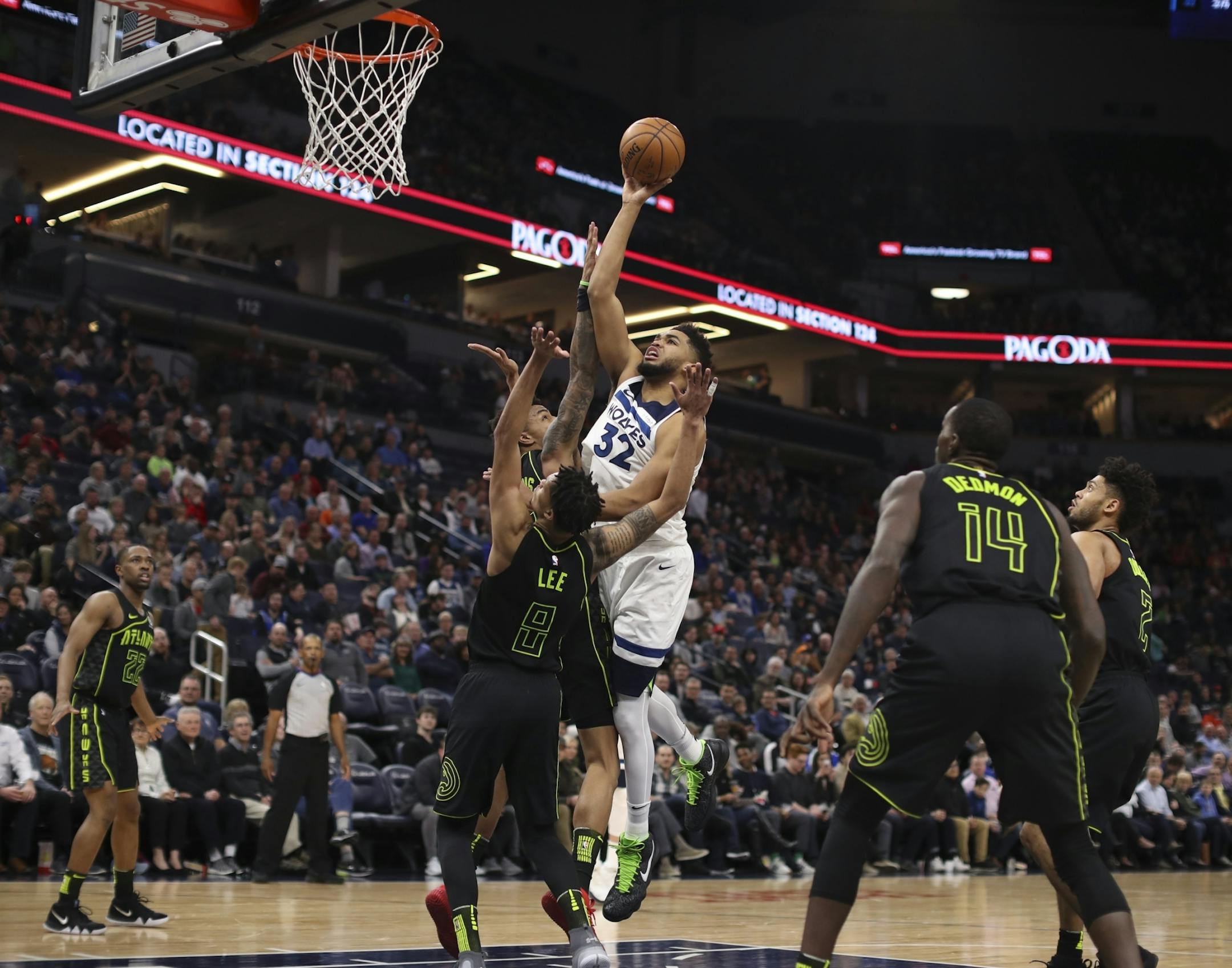 Timberwolves center Karl-Anthony Towns (32) put up fourth quarter shot over Atlanta Hawks forward John Collins (20) and guard Damion Lee (8) on a night that saw him scoring a franchise record 56 points.