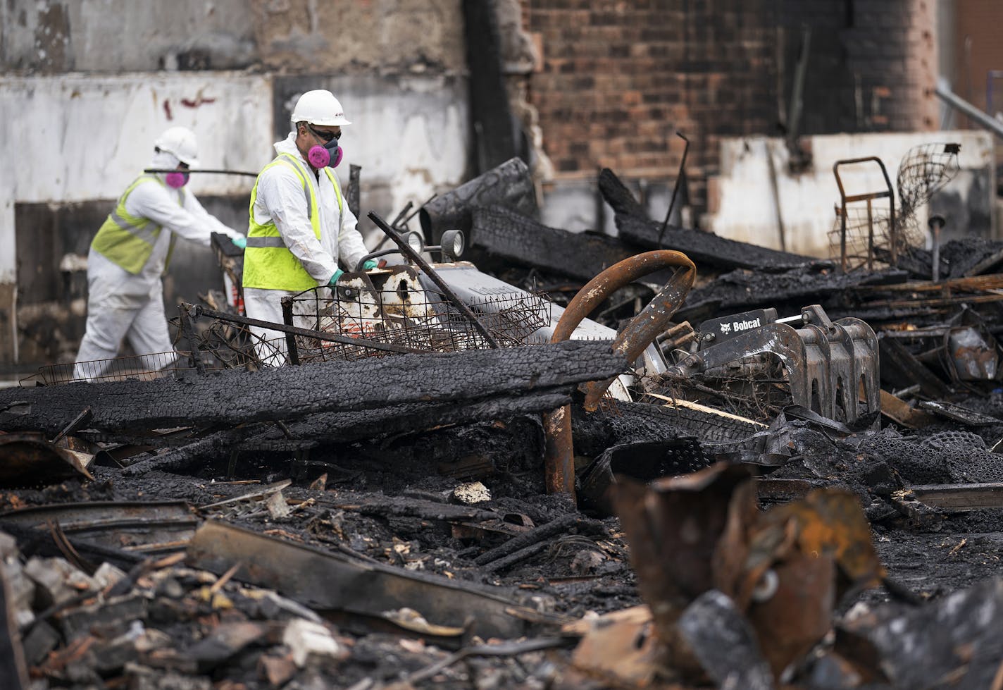 Construction crews removed rubbish from Max It Pawn shop in July. Authorities found the charred body of a man in the wreckage of the south Minneapolis pawnshop, nearly two months after the building was torched in the rioting that followed George Floyd's death.