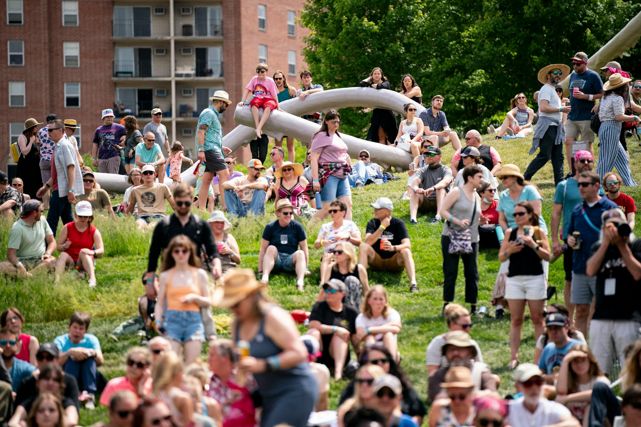 Spectators lounge on the grass while Bombino performs during Rock the Garden.