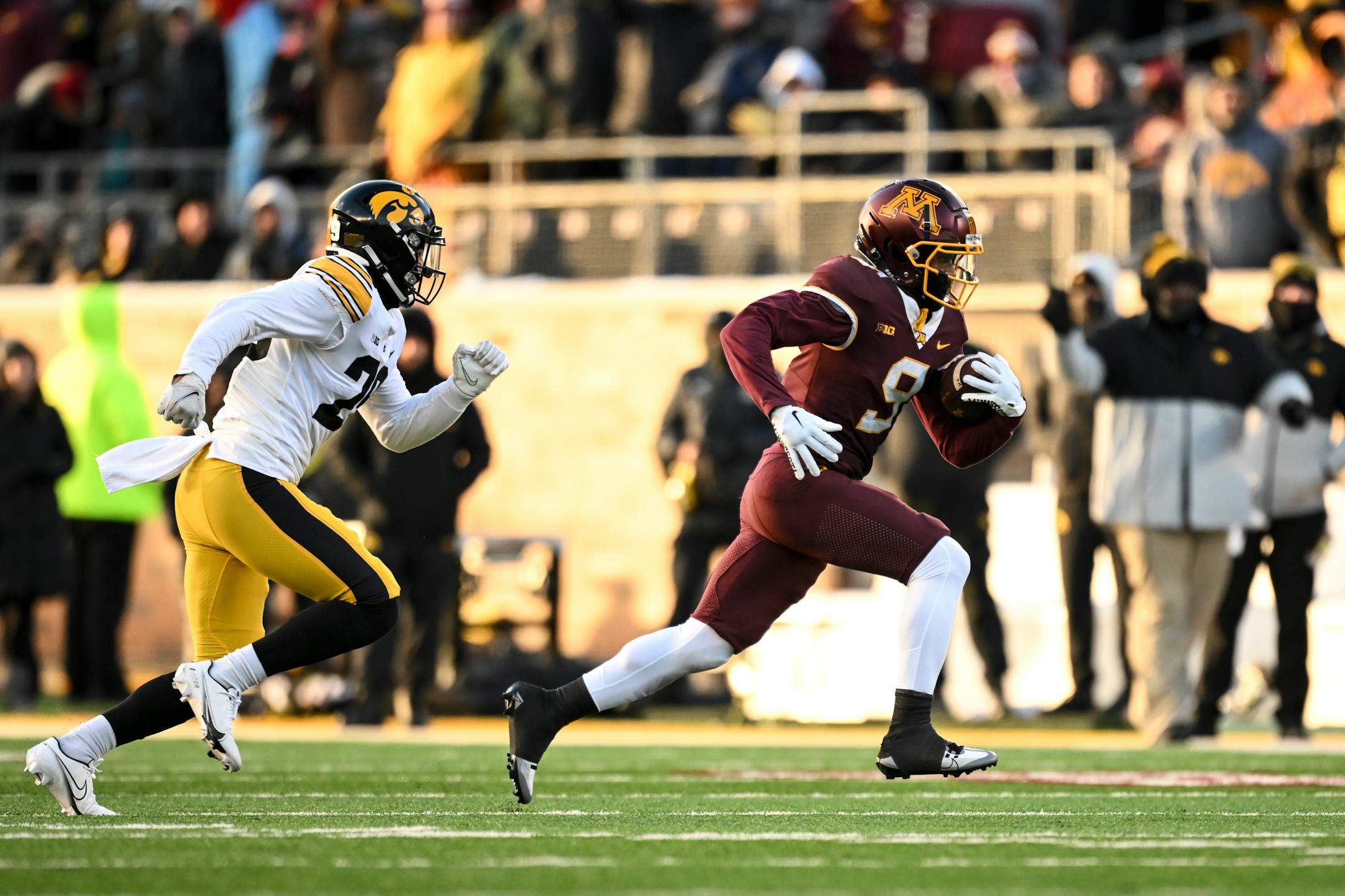Minnesota Gophers wide receiver Daniel Jackson (9) runs the ball after catching a pass for a first down with Iowa Hawkeyes defensive back Sebastian Castro (29) in pursuit during the first half.