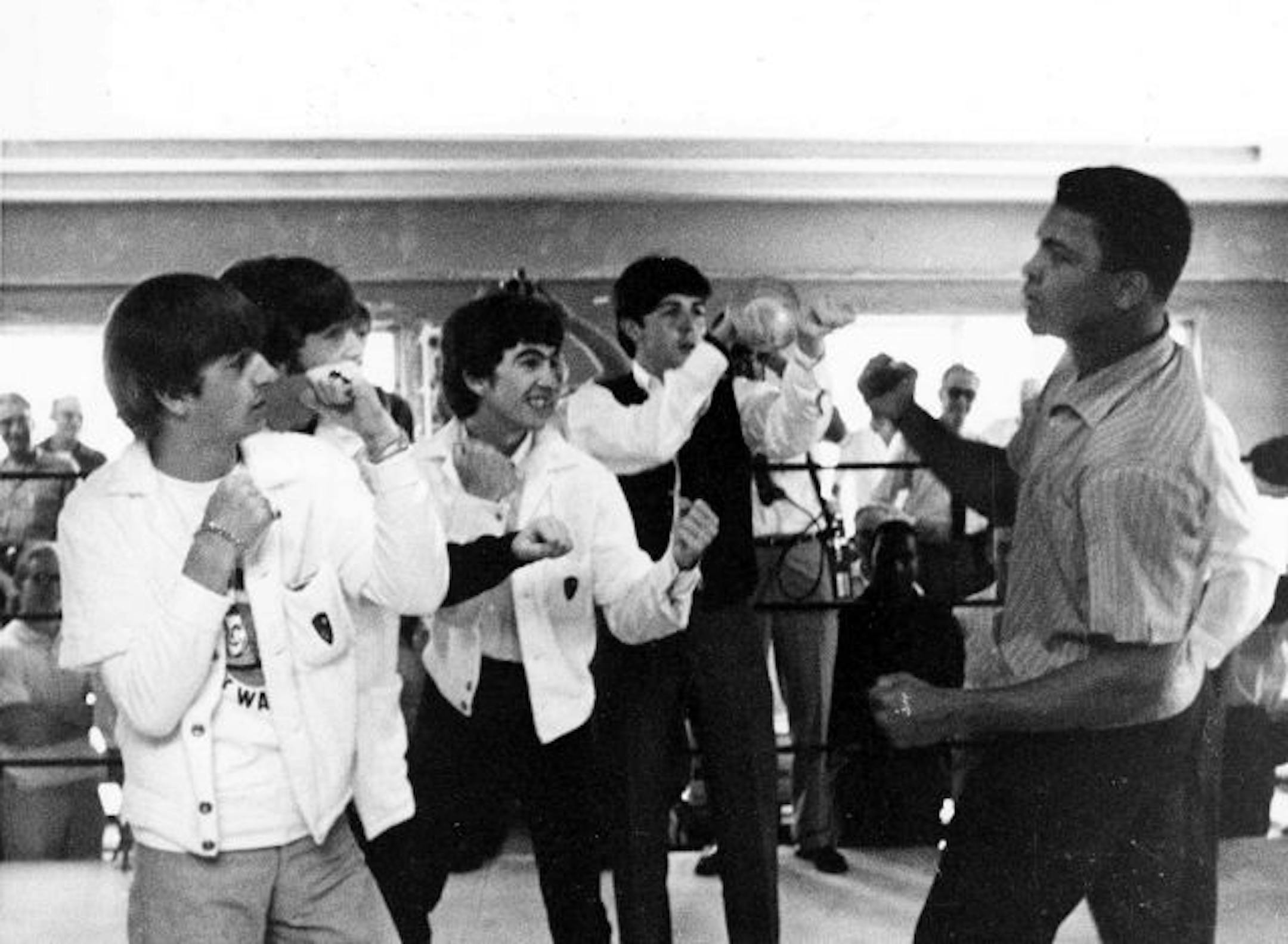 The Beatles, from left, Ringo Starr, John Lennon, George Harrison, and Paul McCartney spar up to Cassius Clay while visiting the heavyweight contender at his training camp in Miami Beach, Fla. ,Feb. 18,1964.