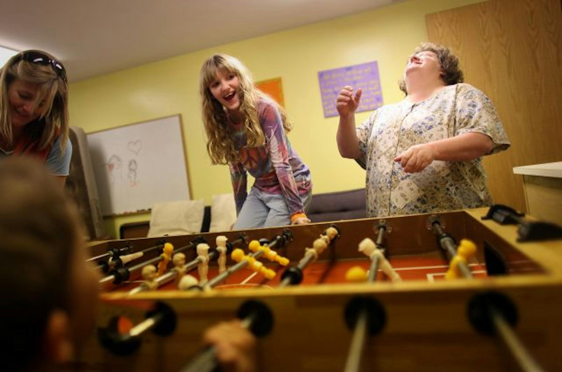 Katelyn Kneer, 10, and her mom, Jennifer Erickson, played foosball at the Edina Community Lutheran Church. Katelyn; her mother, Jennifer; father, Scott Kneer, and sister, Hannah, 9, are in a program for homeless families who spend nights at area churches.