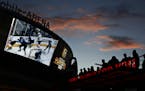 In this May 2, 2018, photo, people watch a second-round playoff series hockey game at a Vegas Golden Knights watch party outside T-Mobile Arena in Las