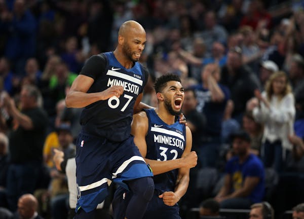 Timberwolves center Karl-Anthony Towns (32) right celebrated a three-point shot with forward Taj Gibson