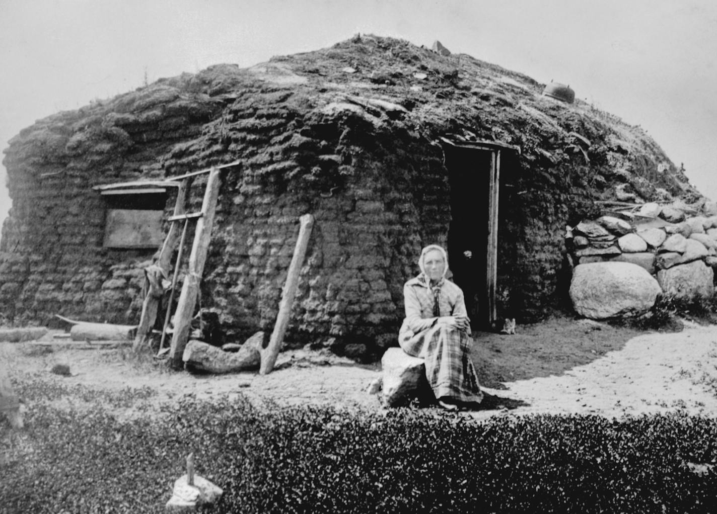 Mrs. Beret Olesdater Hagebak seated in front of Hagebeck sod home located 7 miles east of Madison MN in Lac qui Parle County, ca. 1896 - mn150 Mrs. Beret Hagebak, a Norwegian settler, in front of the sod house her family built in 1872, seven miles east of Madison, Minn. The photograph was taken in 1896. In 1850 the whole territory of Minnesota had a population of only about 6,000 white people. By 1880 it had reached 780,000. In those 30 years, immigrants-from Europe, Canada and the eastern Unite