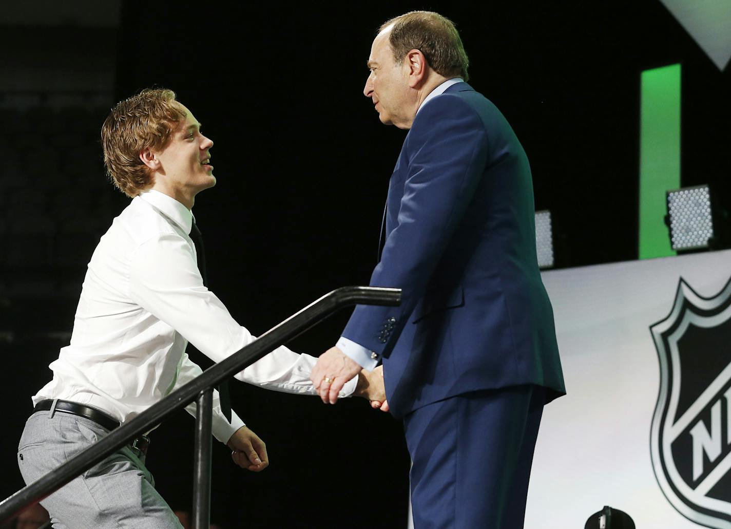 Filip Johansson, left, of Sweden, is greeted by NHL Commissioner Gary Bettman after being selected by the Minnesota Wild during the NHL hockey draft in Dallas, Friday, June 22, 2018. (AP Photo/Michael Ainsworth)