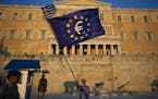 A demonstrator waves a European Union flag in front of the Greek Parliament during a rally in Athens, Thursday, July 9, 2015. Hopes that Greece can ge