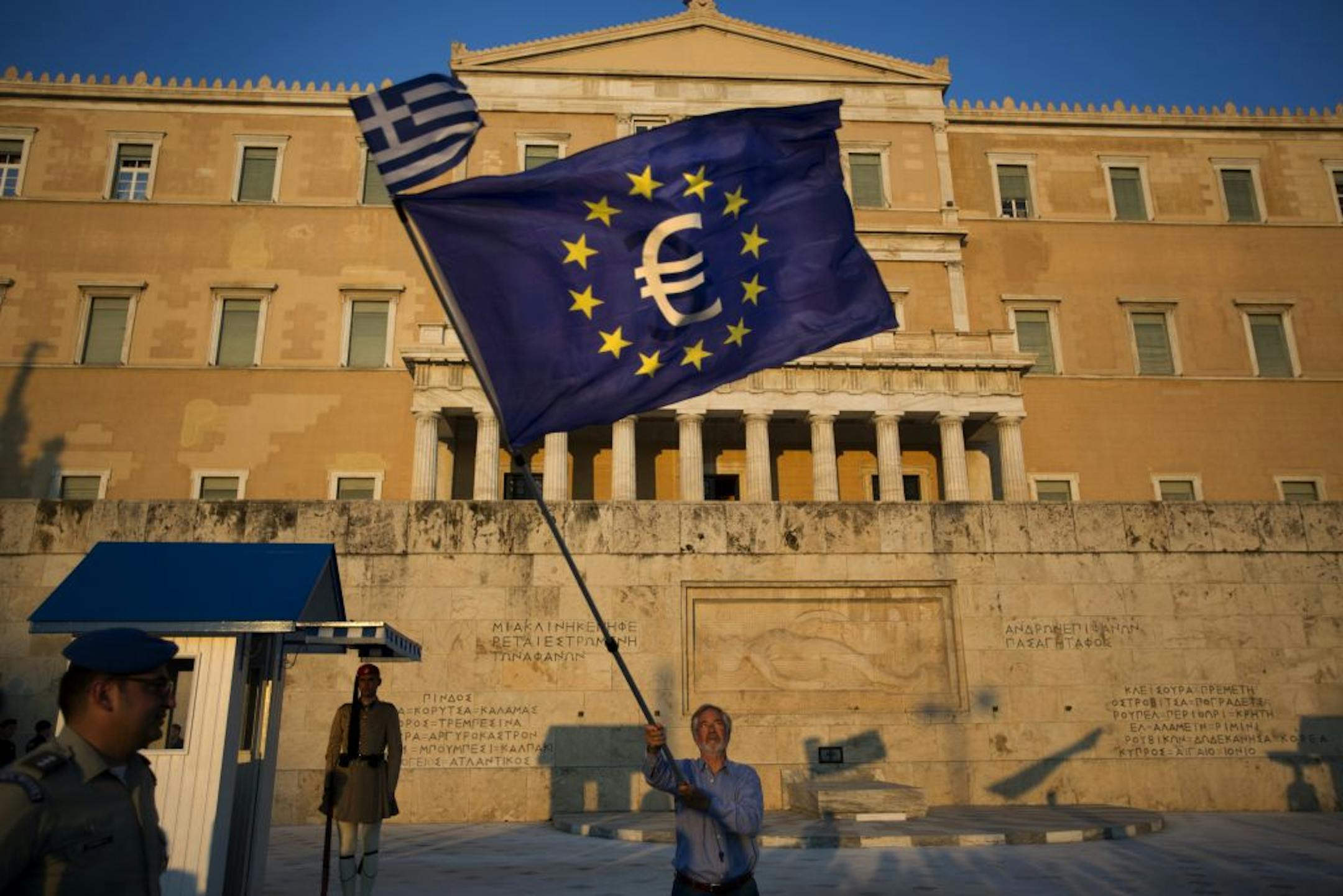 A demonstrator waves a European Union flag in front of the Greek Parliament during a rally in Athens, Thursday, July 9, 2015. Hopes that Greece can get a rescue deal that will prevent a catastrophic exit from the euro rose on Thursday, after key creditors said they were open to discussing how to ease the country's debt load, a long-time sticking point in their talks.