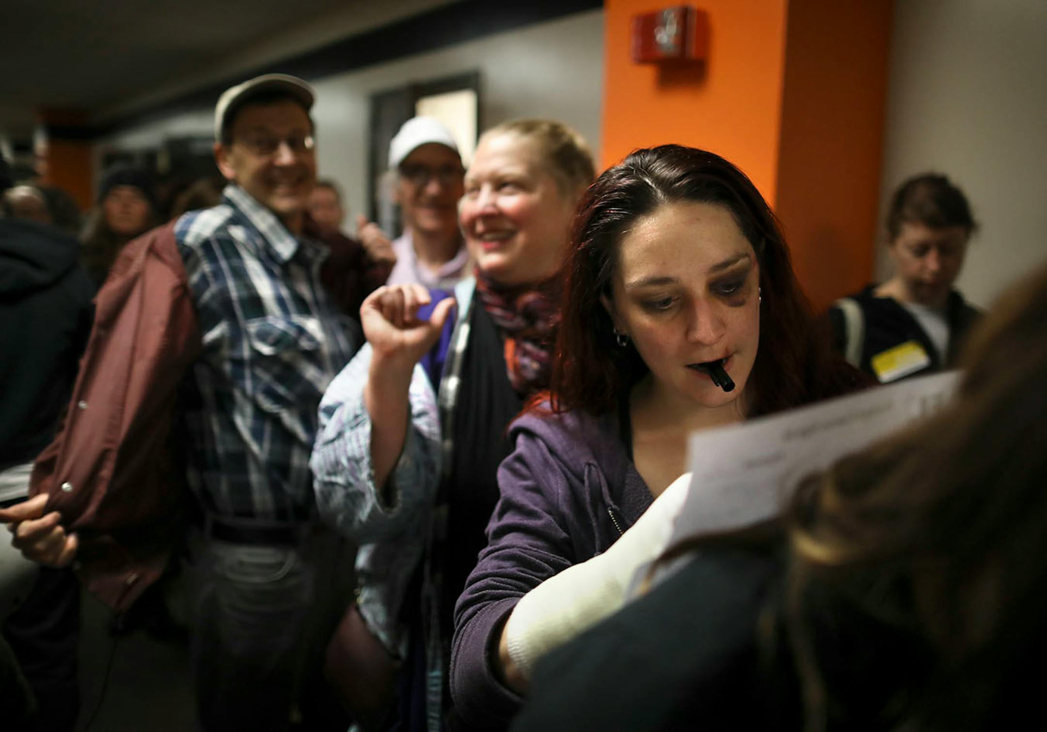 Kit Shelton signed in for the Ward 9, Precinct 2 caucus on the back of volunteer Emily Torgrimson.