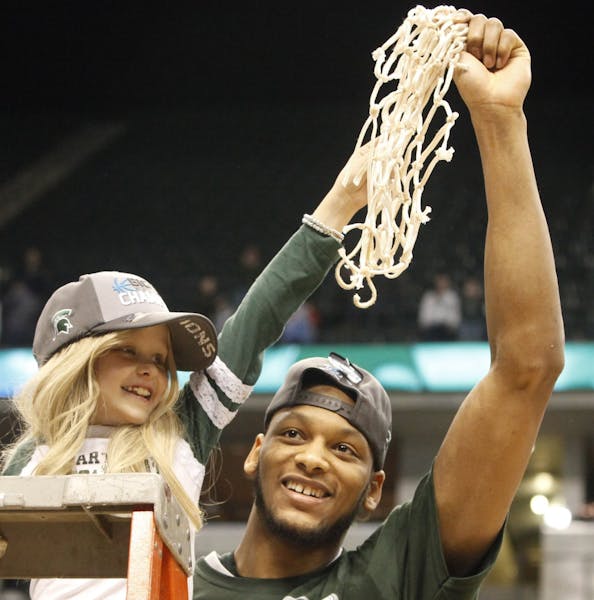 Michigan State Spartans forward Adreian Payne, left, cuts the net with Lacey Holsworth after Michigan State defeated Michigan for the Big Ten champion
