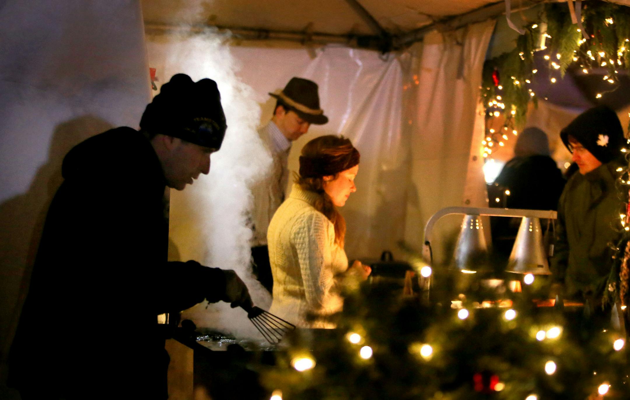 Holidazzle kicked off tonight for the holiday season at Loring Park with fireworks Friday, Nov. 27, 2015, in Minneapolis, MN. Here, Nicholas Burbach, front, tends to potato pancakes and Jagerschnitzel at the family's Holidazzle stand. Behind Burbach is Peter Schmitt, center, and Burbach's wife Sarah Burbach.](DAVID JOLES/STARTRIBUNE)djoles@startribune.com Holidazzle kicked tonight for the holiday season with fireworks at Loring Park Friday, Nov. 27, 2015, in Minneapolis, MN.**Nicholas Burbach,Pe