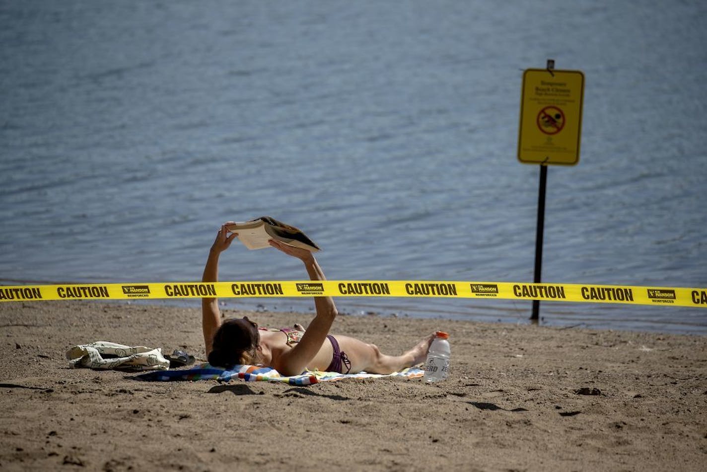 Rachel Soukup, cq, who was more than happy to take in the sun and a book, was also surprised to see very few people at Lake Nokomis beach, Friday, August 30, 2019 in Minneapolis, MN. The beach would normally be filled with people on this holiday weekend.