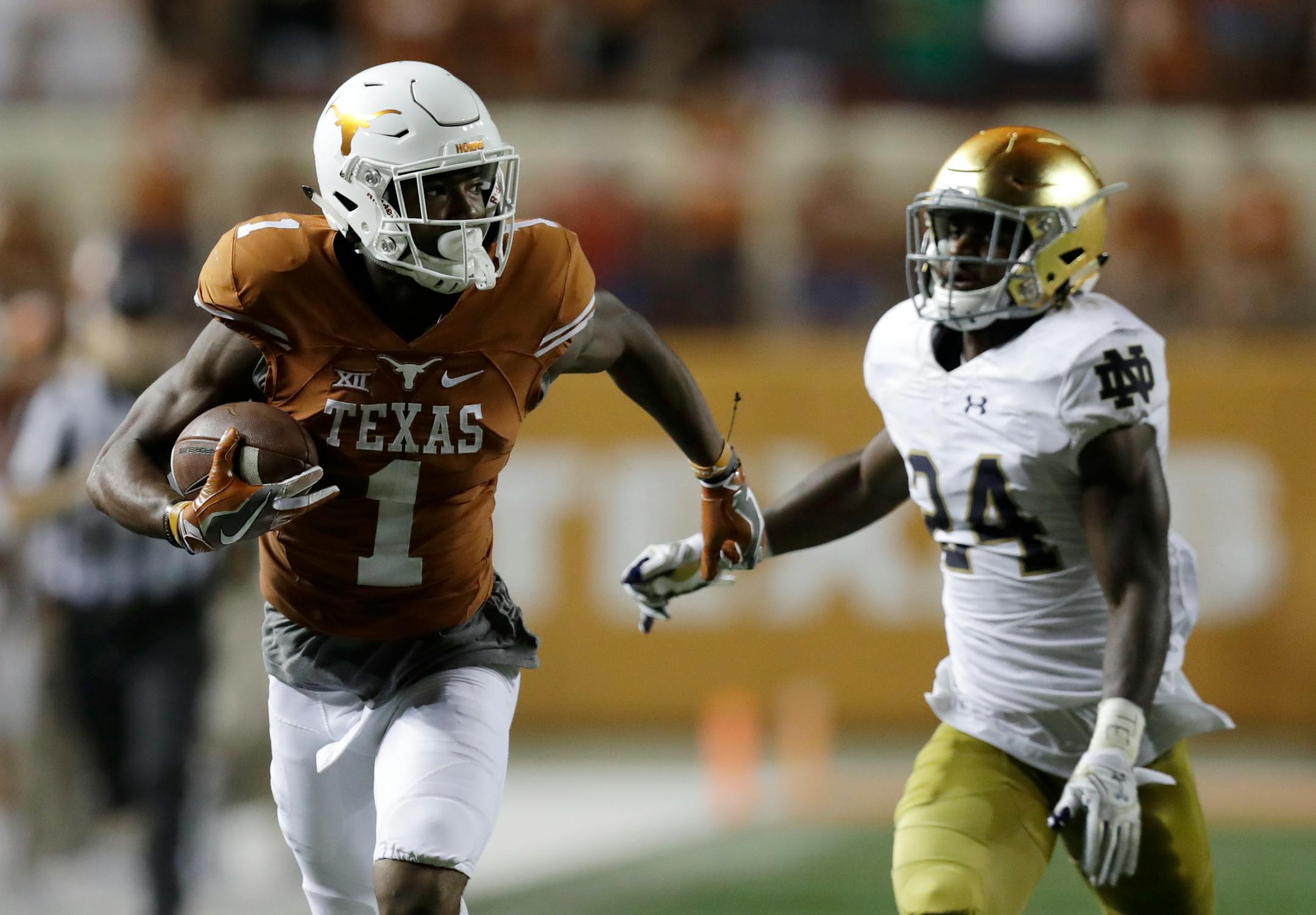 Texas wide receiver John Burt ran from Notre Dame defensive back Nick Coleman during a 72-yard touchdown reception in the second half Sunday in Austin, Texas.