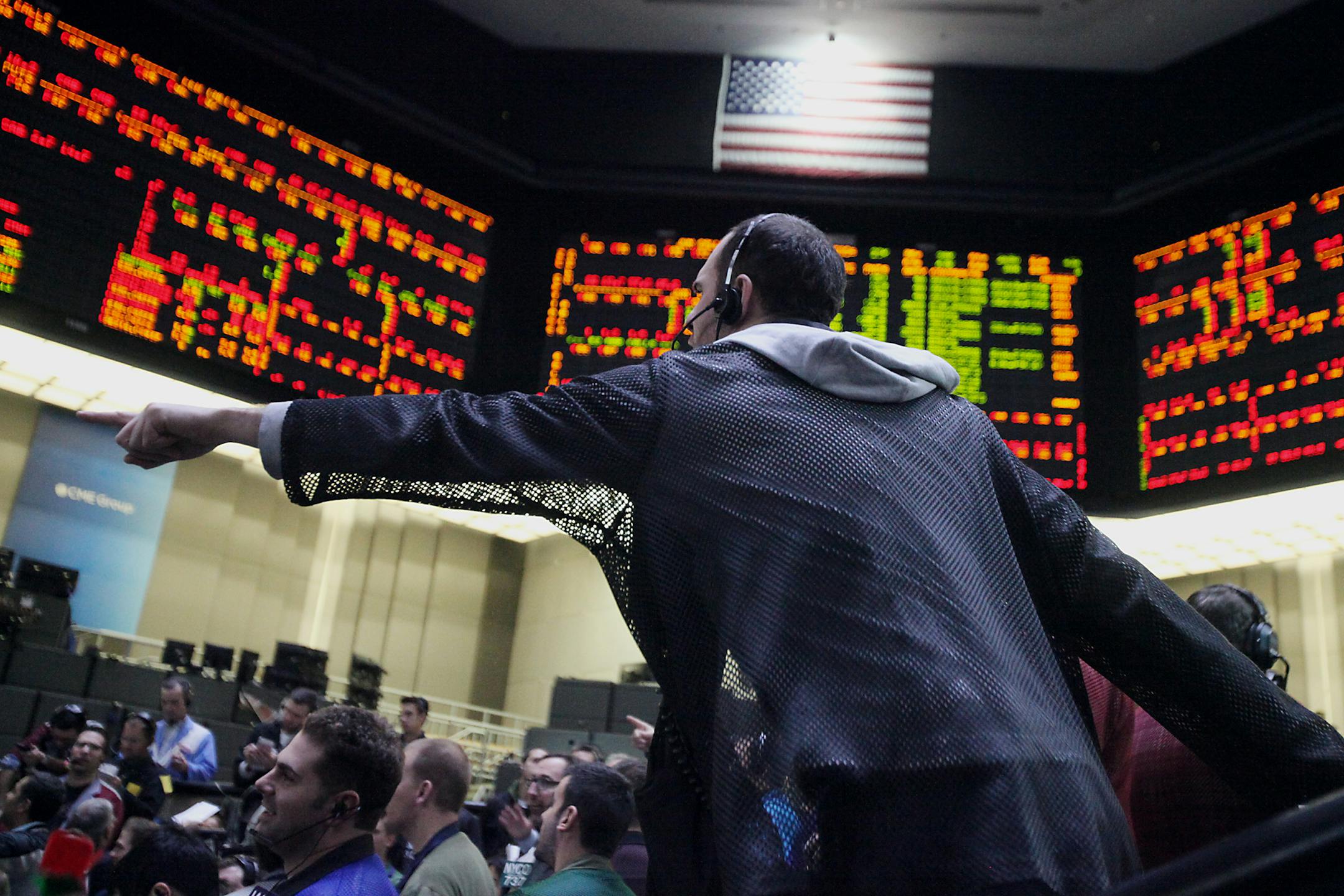 A trader signals orders on the financial floor at the CME Group Inc.'s Chicago Board of Trade in Chicago, Illinois, U.S., on Tuesday, Dec. 31, 2013. U.S. stocks rose, with the Standard & Poor's 500 Index poised for its biggest annual advance since 1997, as increases in consumer confidence and housing prices bolstered confidence in the world�s largest economy. Photographer: Tim Boyle/Bloomberg