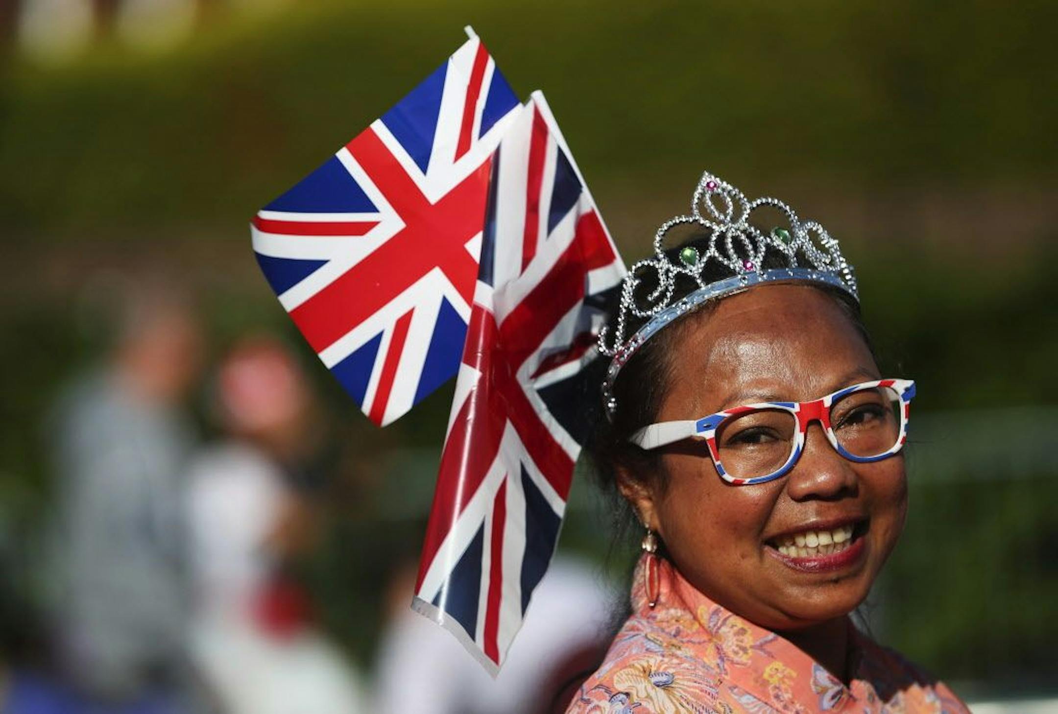 A Royal fan smiles as she stands near the Long Walk before the wedding ceremony of Prince Harry and Meghan Markle at St. George's Chapel in Windsor Castle in Windsor, near London, England, Saturday, May 19, 2018.