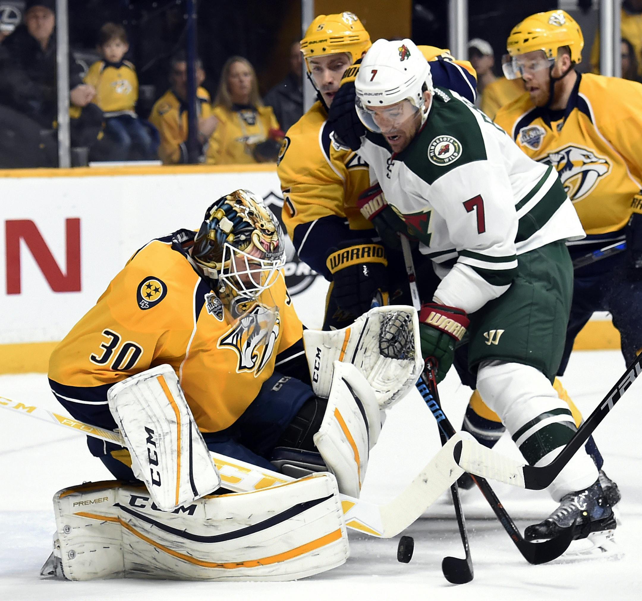 Nashville Predators goalie Carter Hutton (30) stops a shot by Minnesota Wild left wing Chris Porter (7) during the first period of an NHL hockey game Saturday, Jan. 16, 2016, in Nashville, Tenn. (AP Photo/Mark Zaleski)