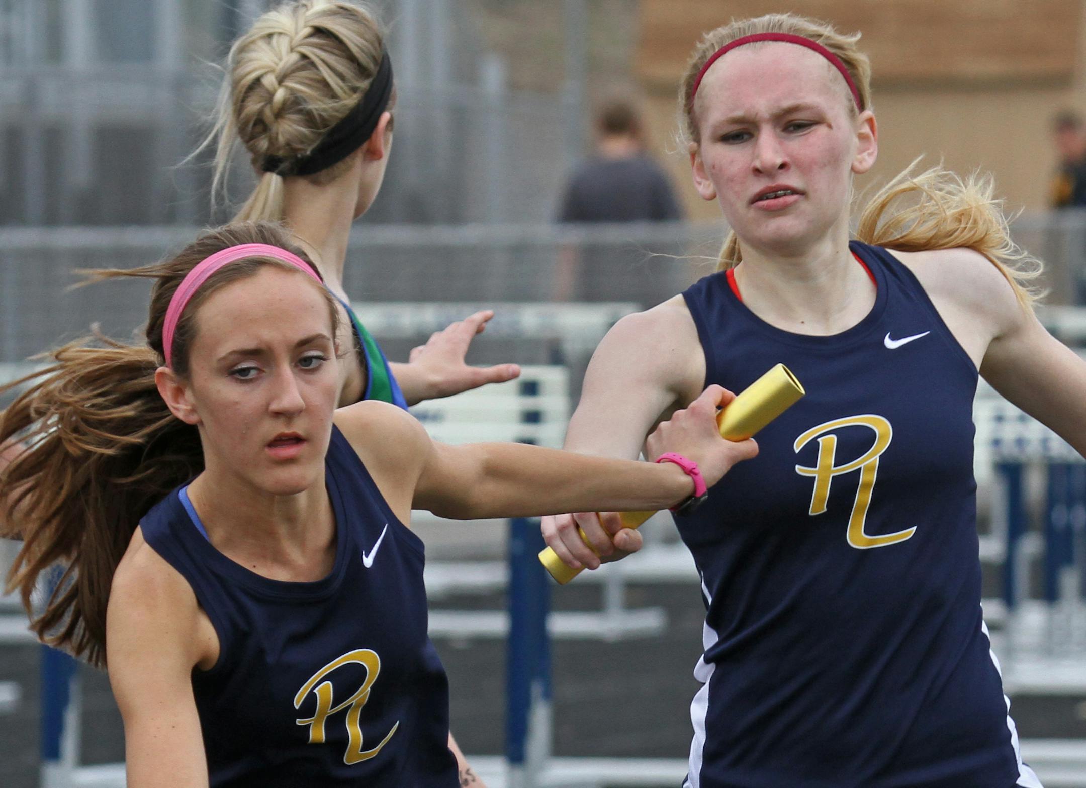 (left to right) Mackenzie Schell of the Prior Lake High School Track Team 4 X 800 relay event, took the hand off from teammate Megan Hovick, during competition at the school on 4/30/13. Bruce Bruce Bisping/Star Tribune Mackenzie Schell, Megan Hovick/source.