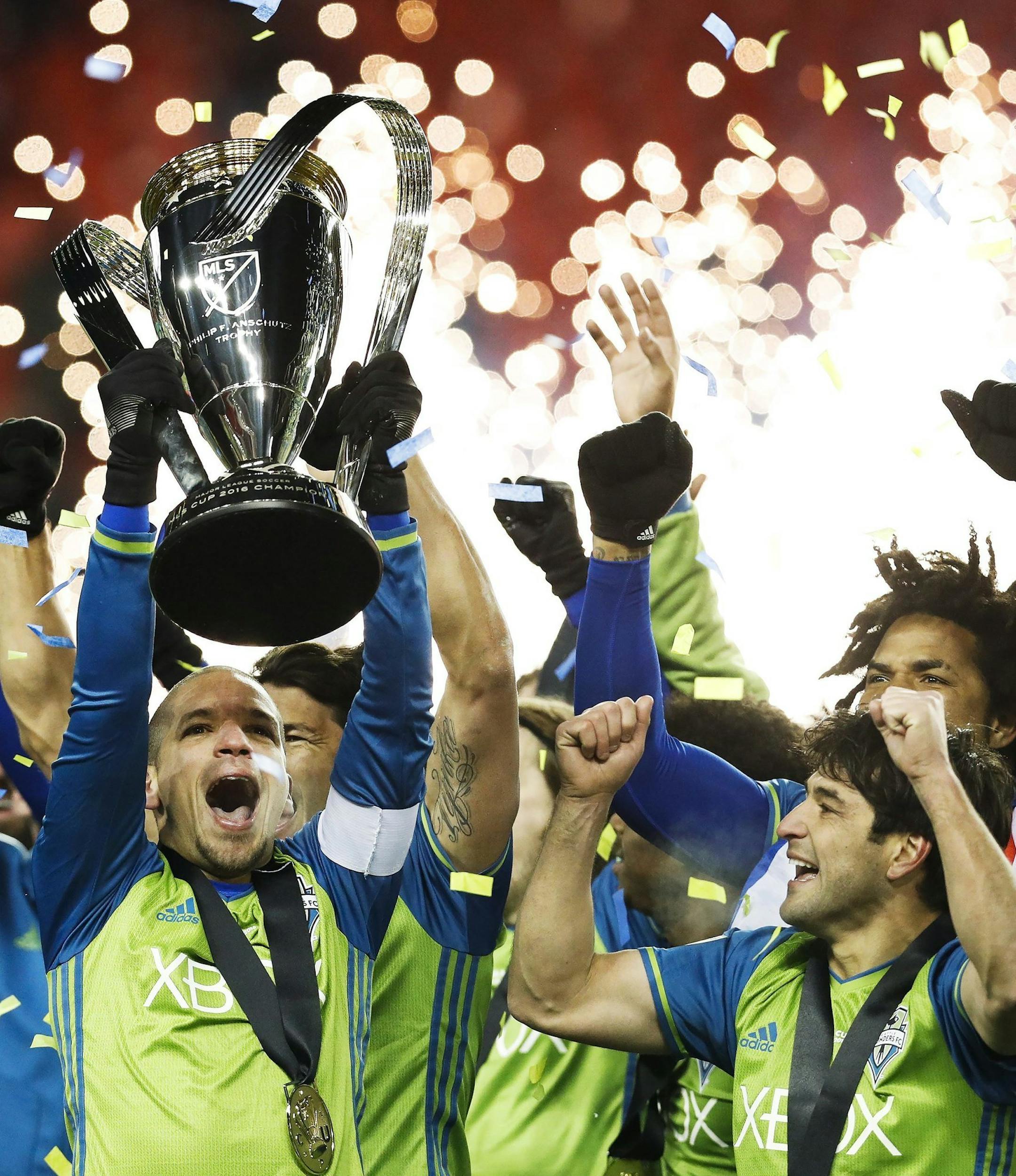 Seattle Sounders midfielder Osvaldo Alonso, front left, hoists soccer's MLS Cup with teammates after defeating Toronto FC, Saturday, Dec. 10, 2016. (Mark Blinch/The Canadian Press via AP) ORG XMIT: NSD107