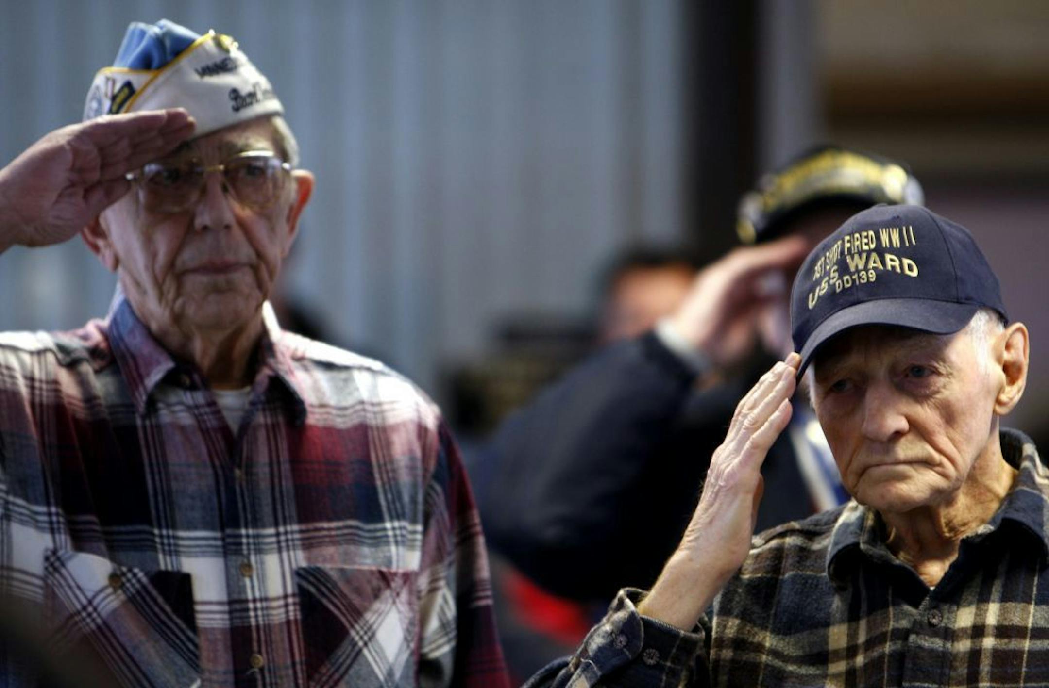 Don Pepin of Maplewood, right, and Herman Hinrichs of Roseville saluted during the playing of Taps to honor those lost on the 67th anniversary of the attack on Pearl Harbor.