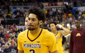Minnesota's Eric Curry (24), Jordan Murphy (3) and others leave the court after an NCAA college basketball game against Michigan in the Big Ten tourna