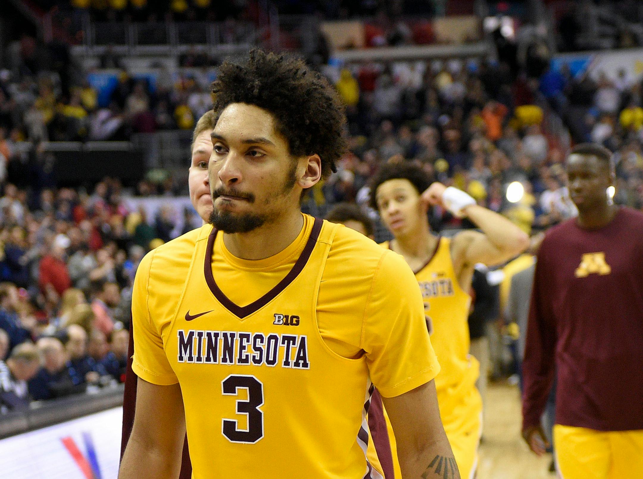 Minnesota's Eric Curry (24), Jordan Murphy (3) and others leave the court after an NCAA college basketball game against Michigan in the Big Ten tournament, Saturday, March 11, 2017, in Washington. Michigan won 84-77. (AP Photo/Nick Wass)