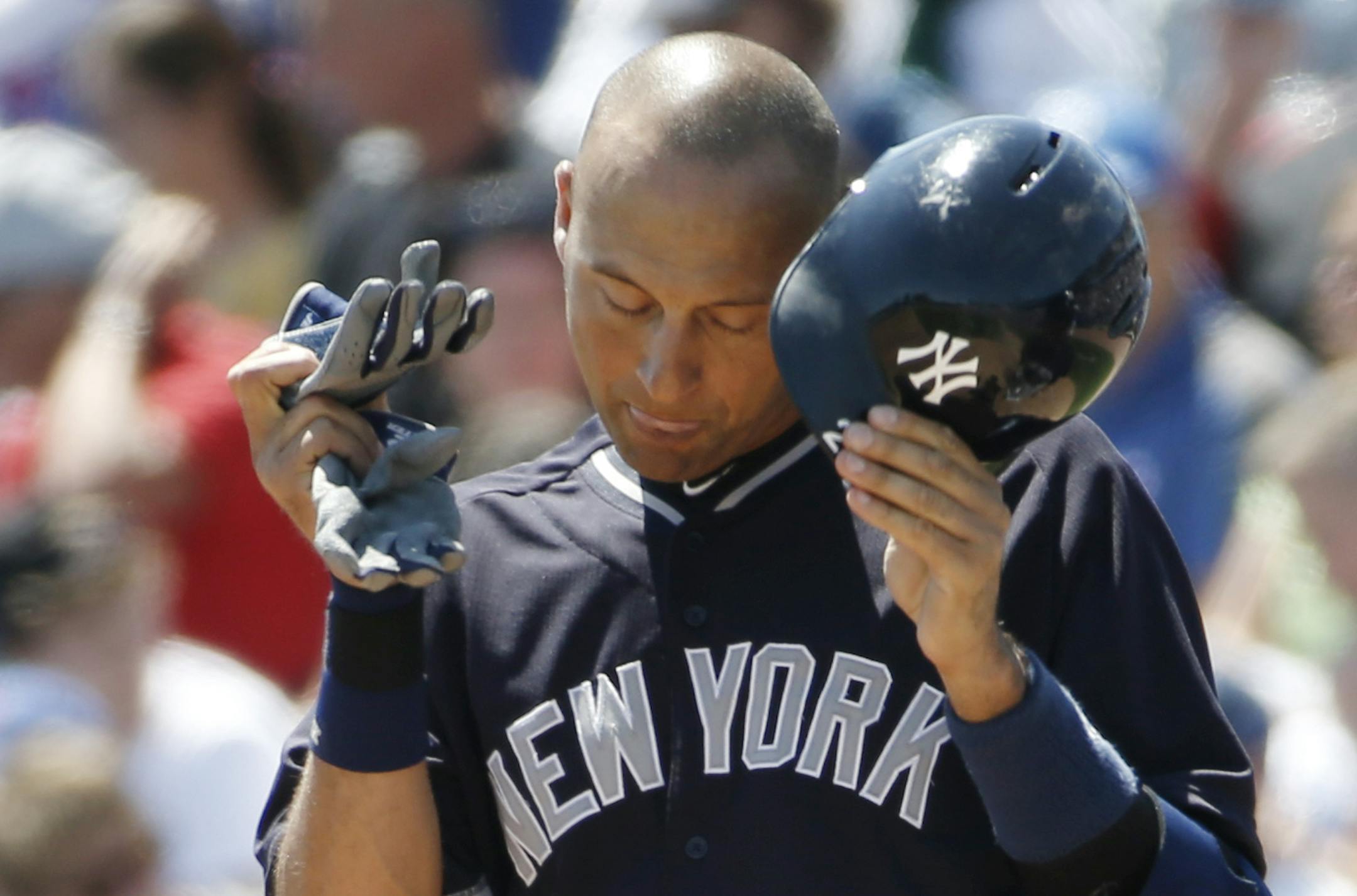 New York Yankees Derek Jeter, right, removes his batting helmet after flying out to center field in the third inning as Toronto Blue Jays right fielder Jose Bautista heads to the dugout in an exhibition baseball game in Dunedin, Fla., Wednesday, March 26, 2014. The Yankees scored six runs off Blue Jays starting pitcher R.A. Dickey but the Blue Jays came from behind with eight runs in the fifth inning to defeat the Yankees 10-6. (AP Photo/Kathy Willens)
