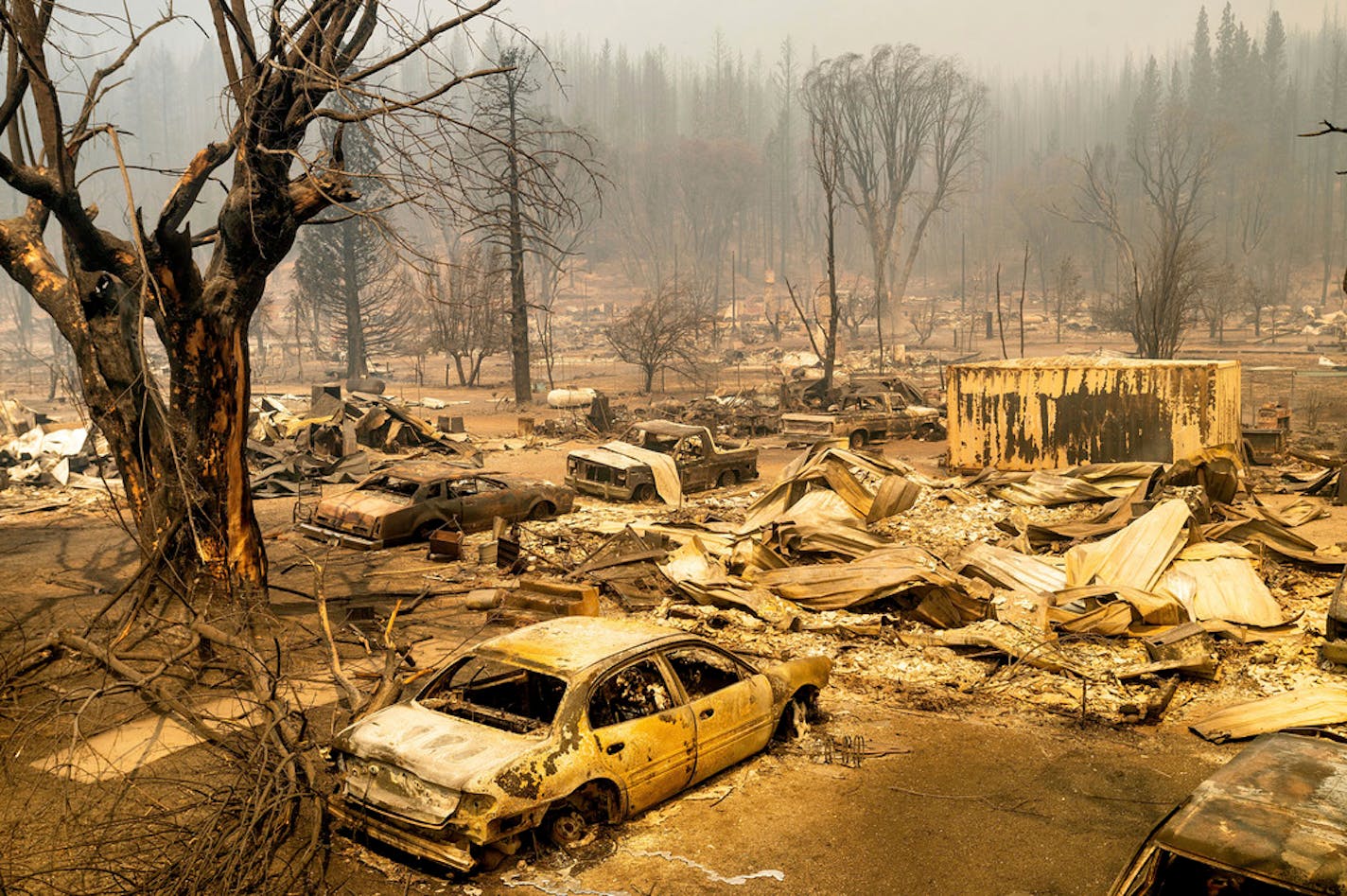 This photo shows cars and homes destroyed by the Dixie Fire line central Greenville on Thursday, Aug. 5, 2021, in Plumas County, Calif. (AP Photo/Noah Berger)