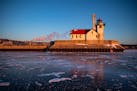 The Duluth Harbor south breakwater outer light was was illuminated by the rising sun over a frozen Lake Superior on Tuesday.