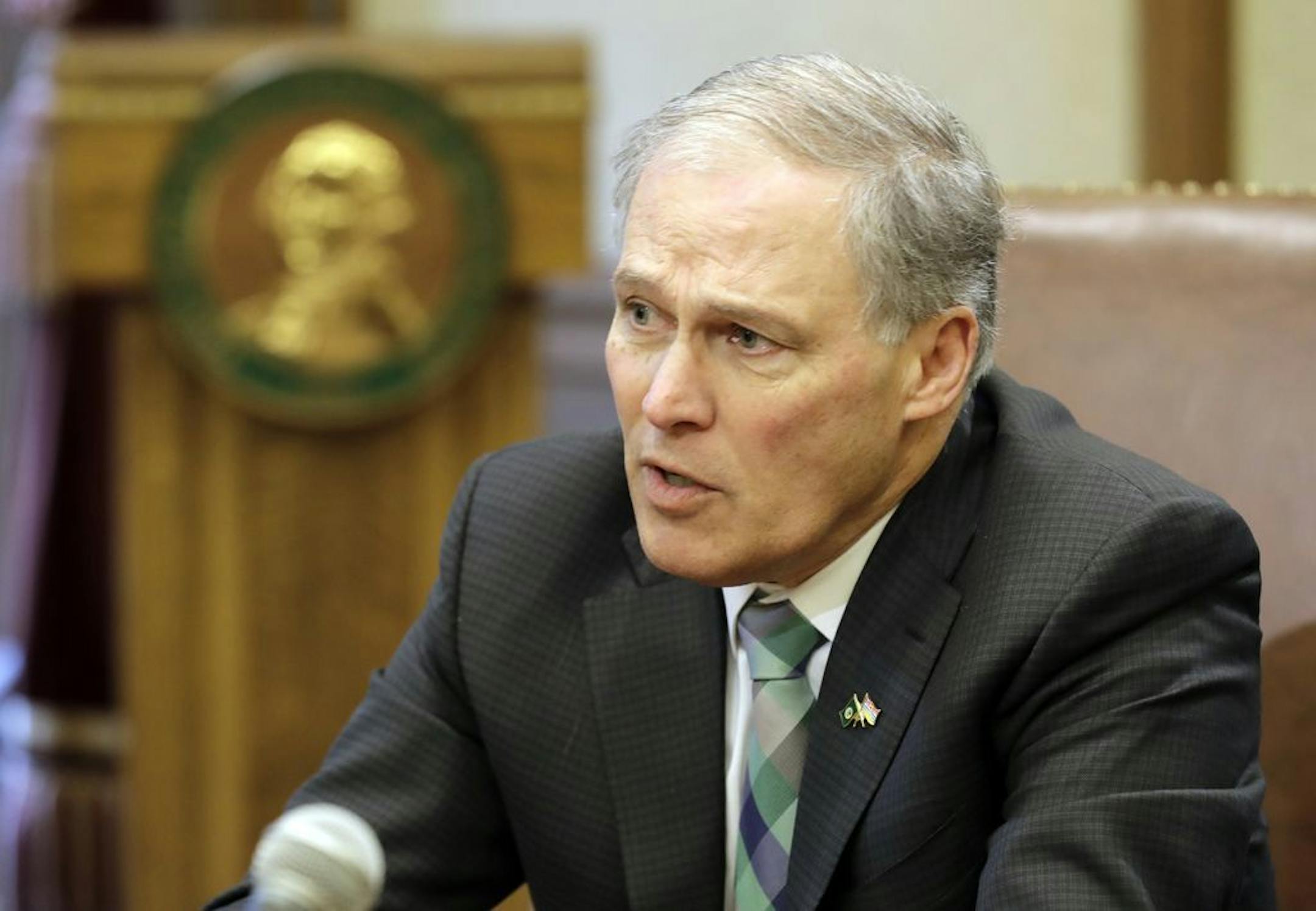 Washington Gov. Jay Inslee talks to reporters after taking part in the signing of a climate agreement with British Columbia Premier John Horgan, Friday, Feb. 8, 2019, at the Capitol in Olympia, Wash. A planned address to a joint session of the Washington Legislature by Horgan was cancelled, as officials cited concerns over a forecast snowstorm in the region.
