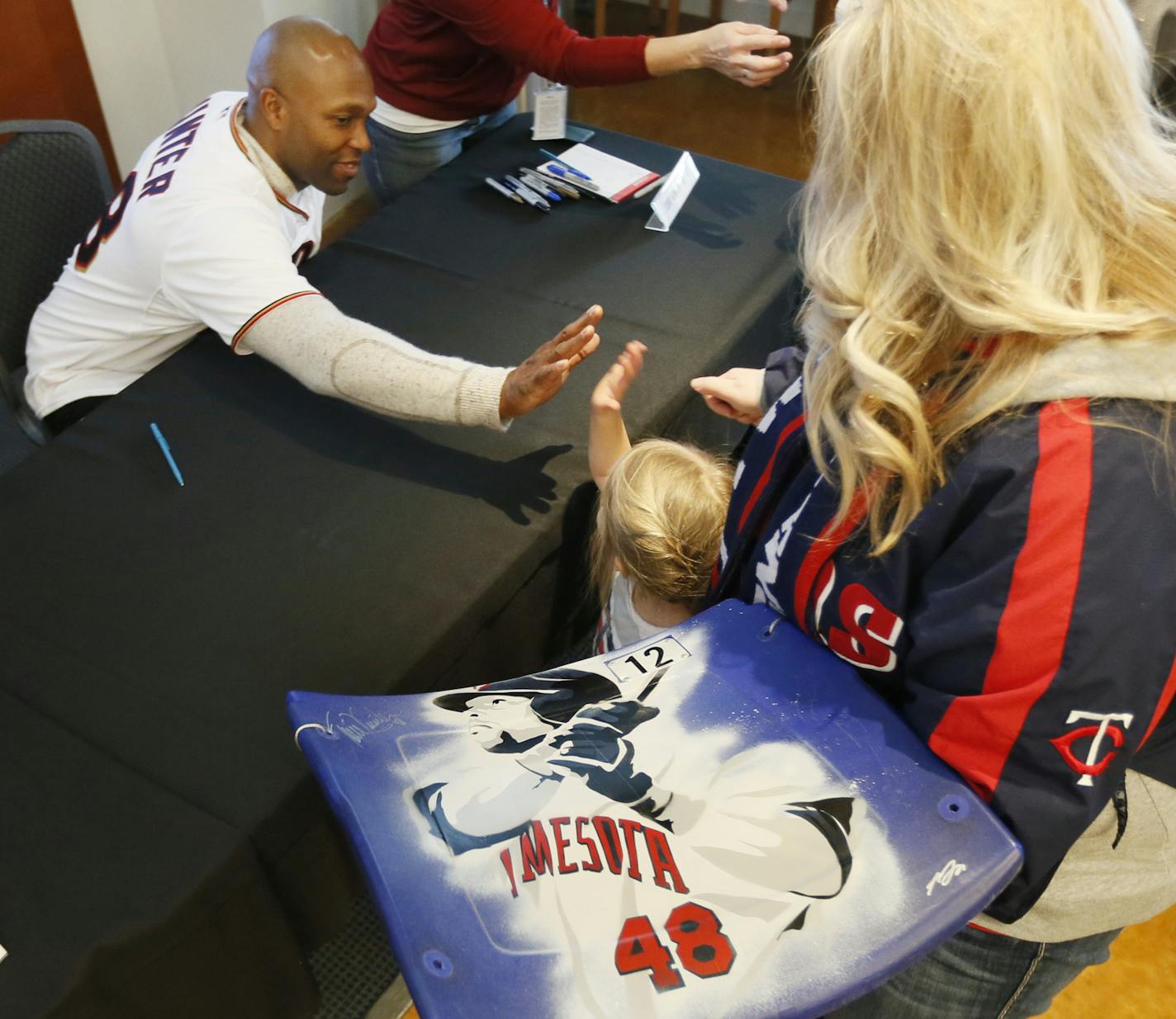 Minnesota Twins outfielder Torii Hunter gave Tenley Irwin 3, a high five during Twins Fest at Target Field Sunday January 25, 2015 Minneapolis, MN. Jackie Irwin was with her daughter and they got Torri to autograph a seat from the metro dome. ] Jerry Holt/ Jerry.Holt@Startribune.com