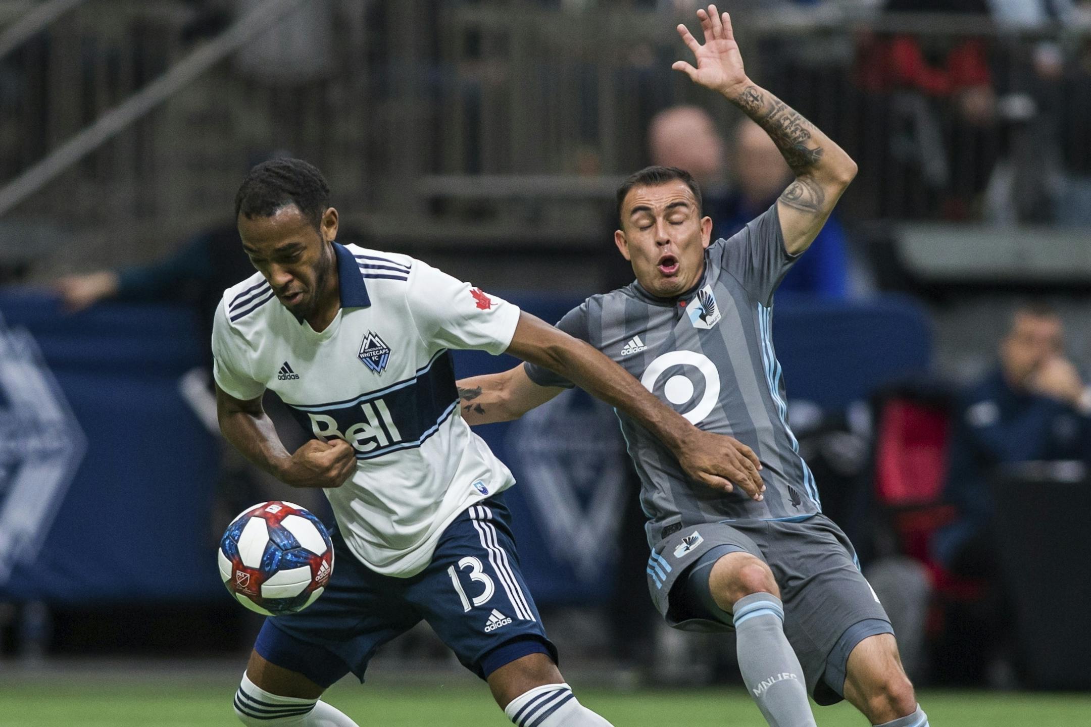 Vancouver Whitecaps' Derek Cornelius (13) plays the ball against Minnesota United's Miguel Ibarra during the first half of an MLS soccer match Saturday, March 2, 2019, in Vancouver, British Columbia.