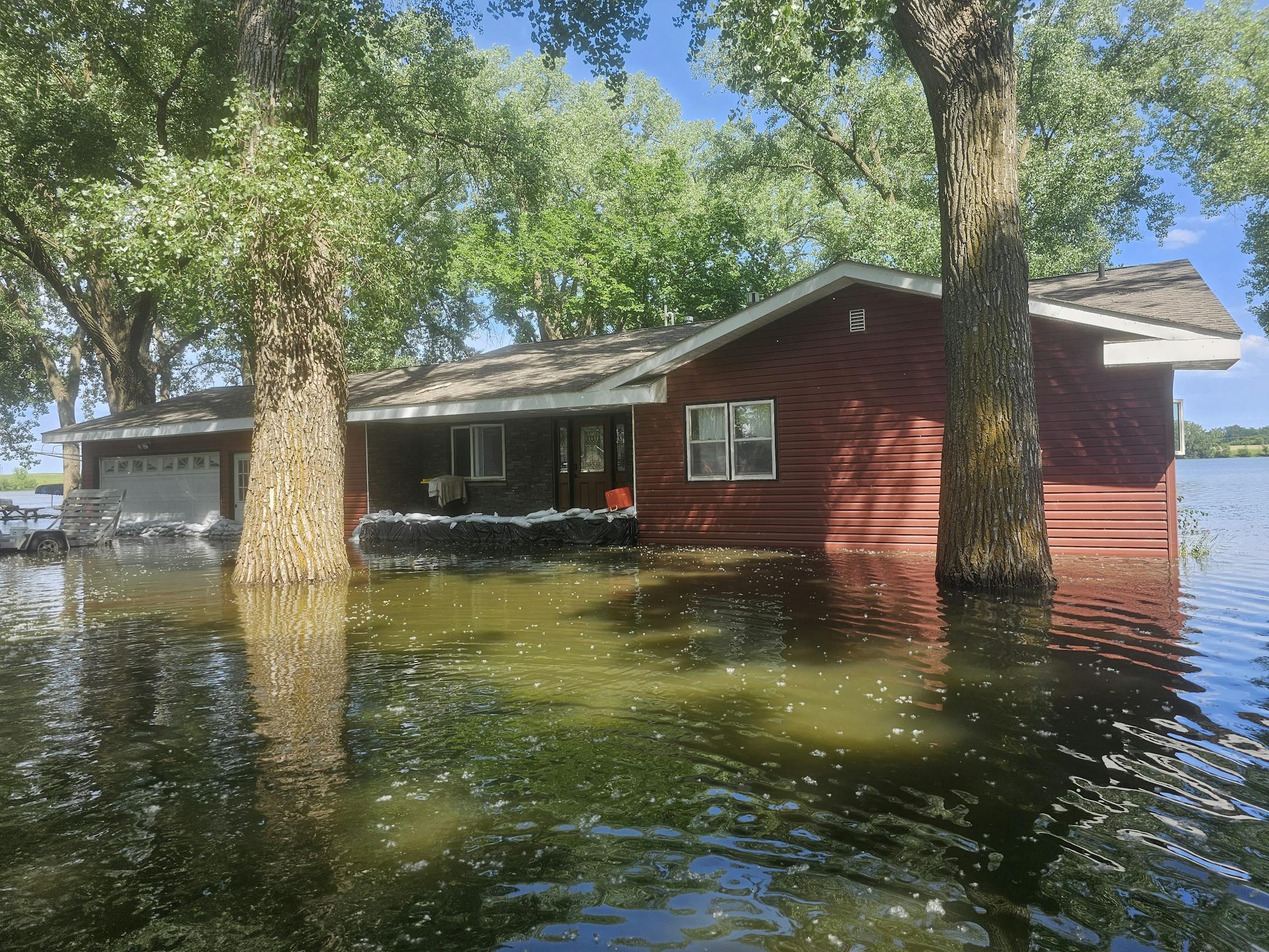 A home in Windom, Minn., is flooded and has sandbags in front of it.