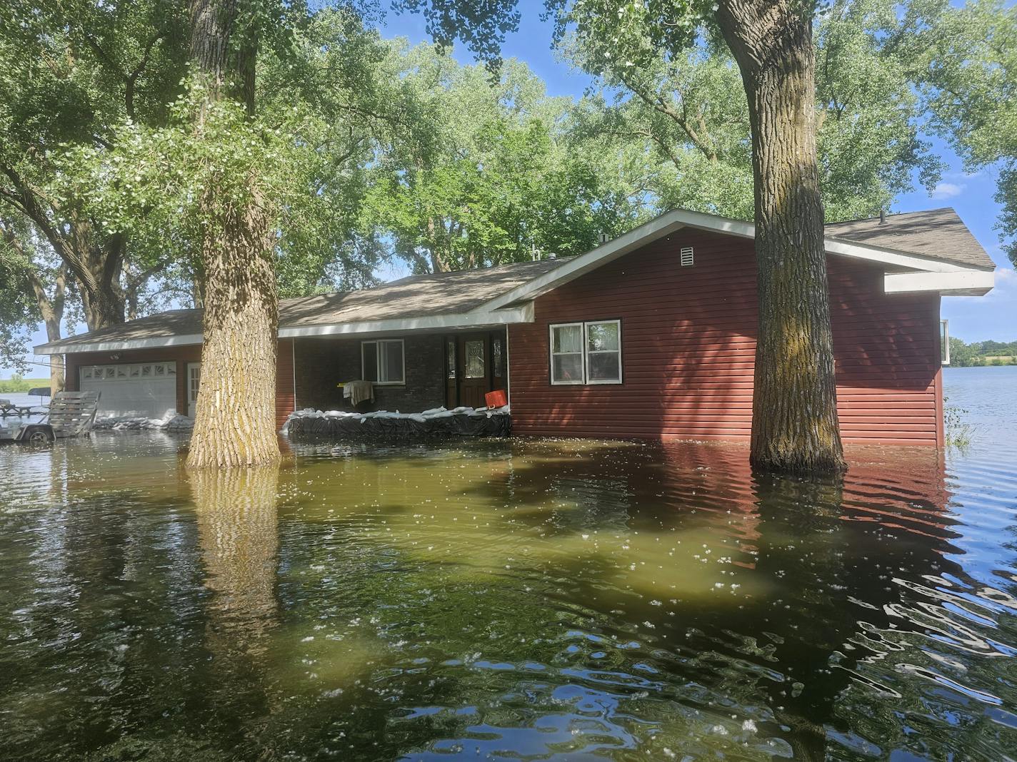 A home in Windom, Minn., is flooded and has sandbags in front of it.