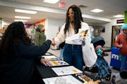 Patricia Rodriguez learns about various career opportunities at a job fair at the CareerForce Center on Wednesday in Minneapolis. The state reported T